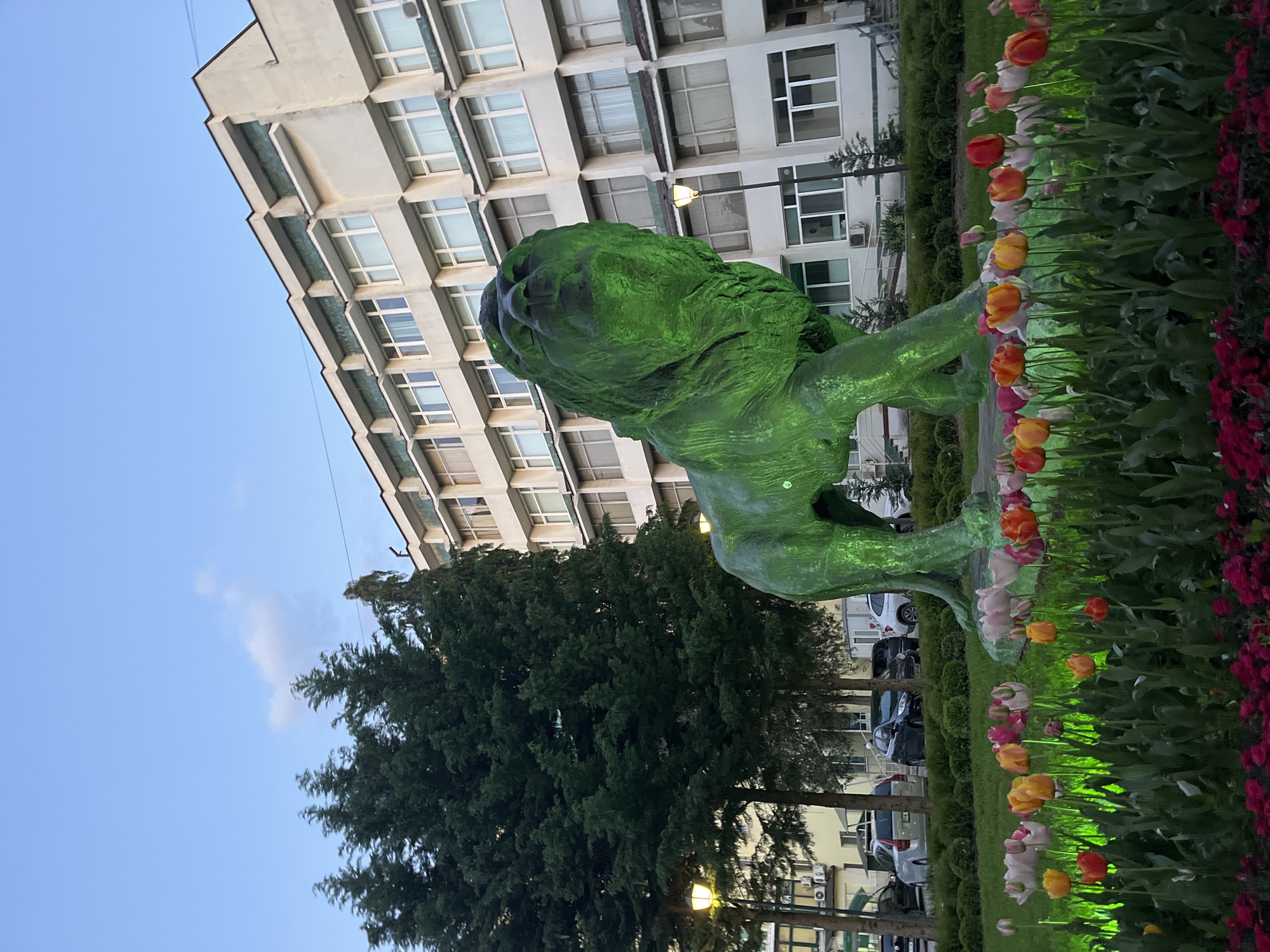 Evening park scene with lion statue, dogs in Pazardzhik