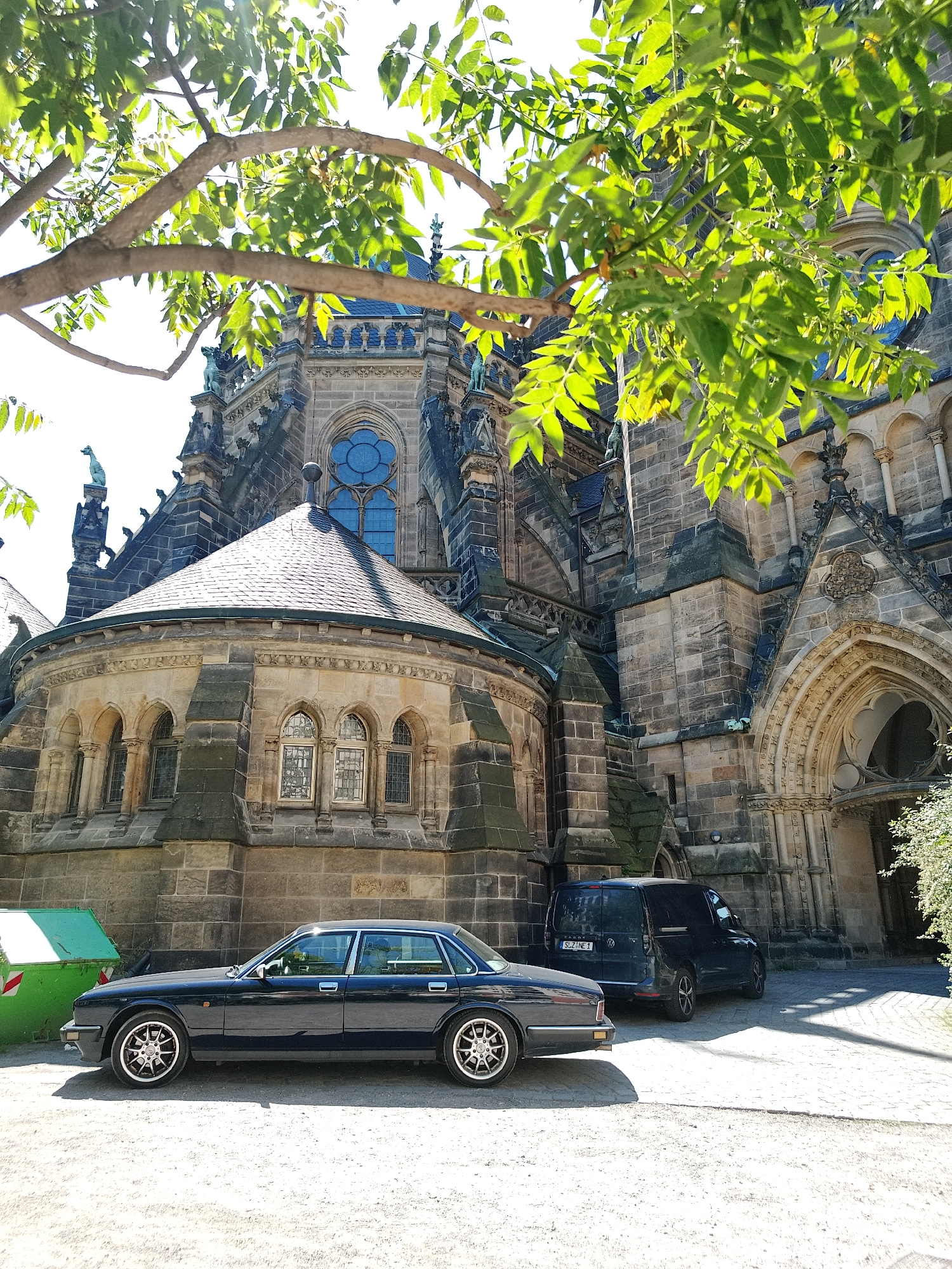 Gothic cathedral, parked Jaguar, street murals, passing tram documented