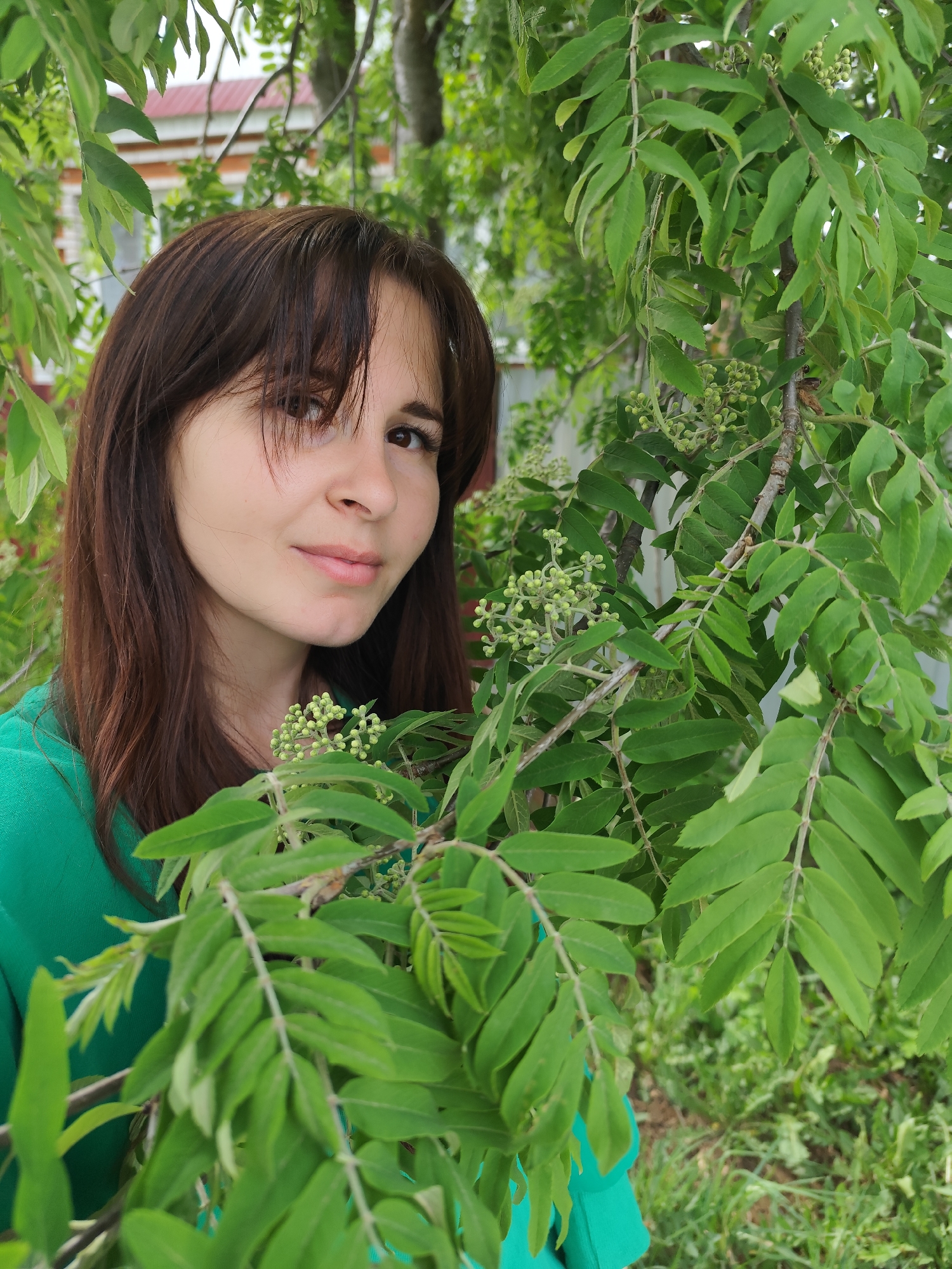 Woman photographed among spring foliage in Russian garden setting