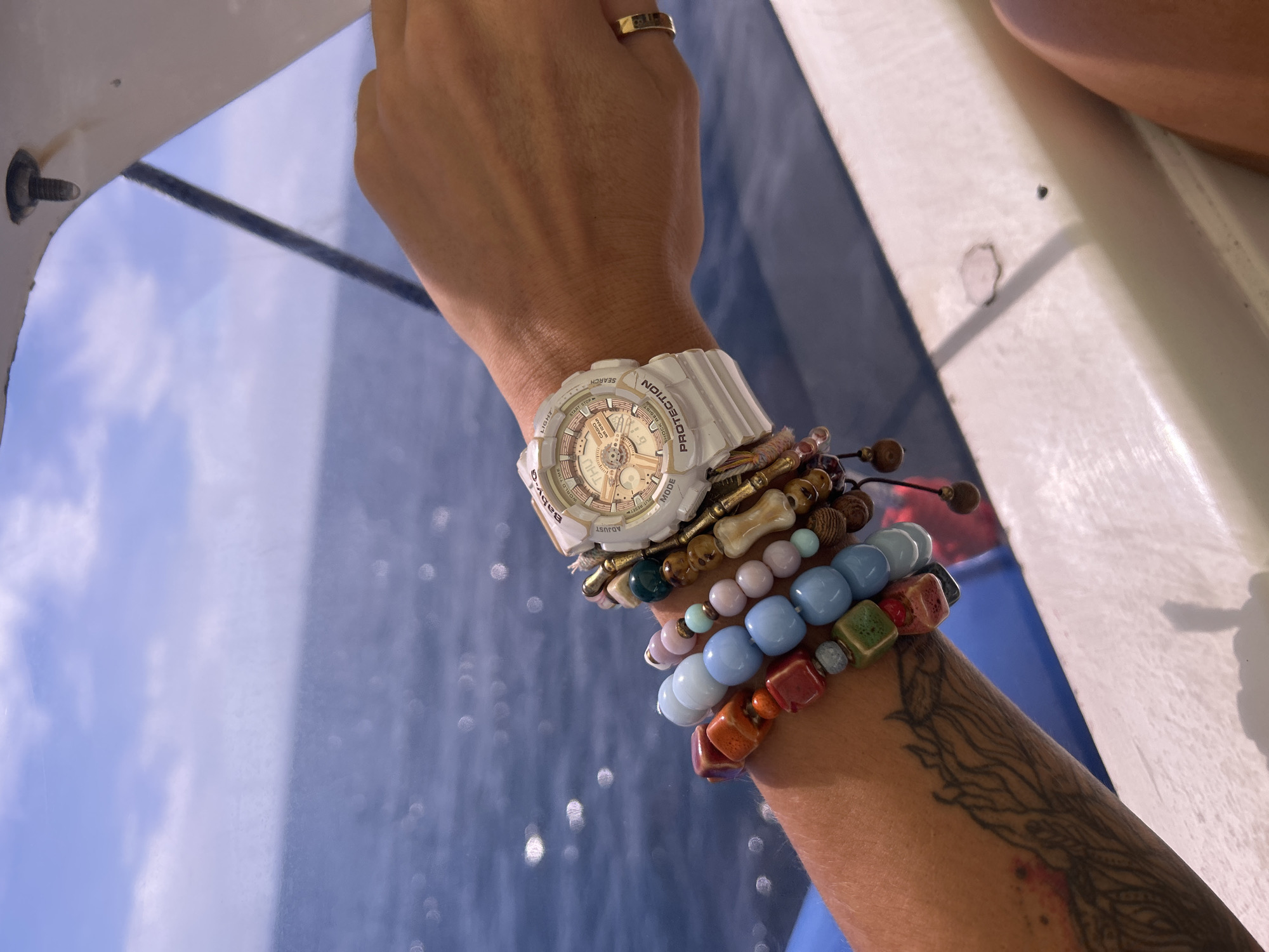 Person with beaded bracelets photographed on boat near Rawai