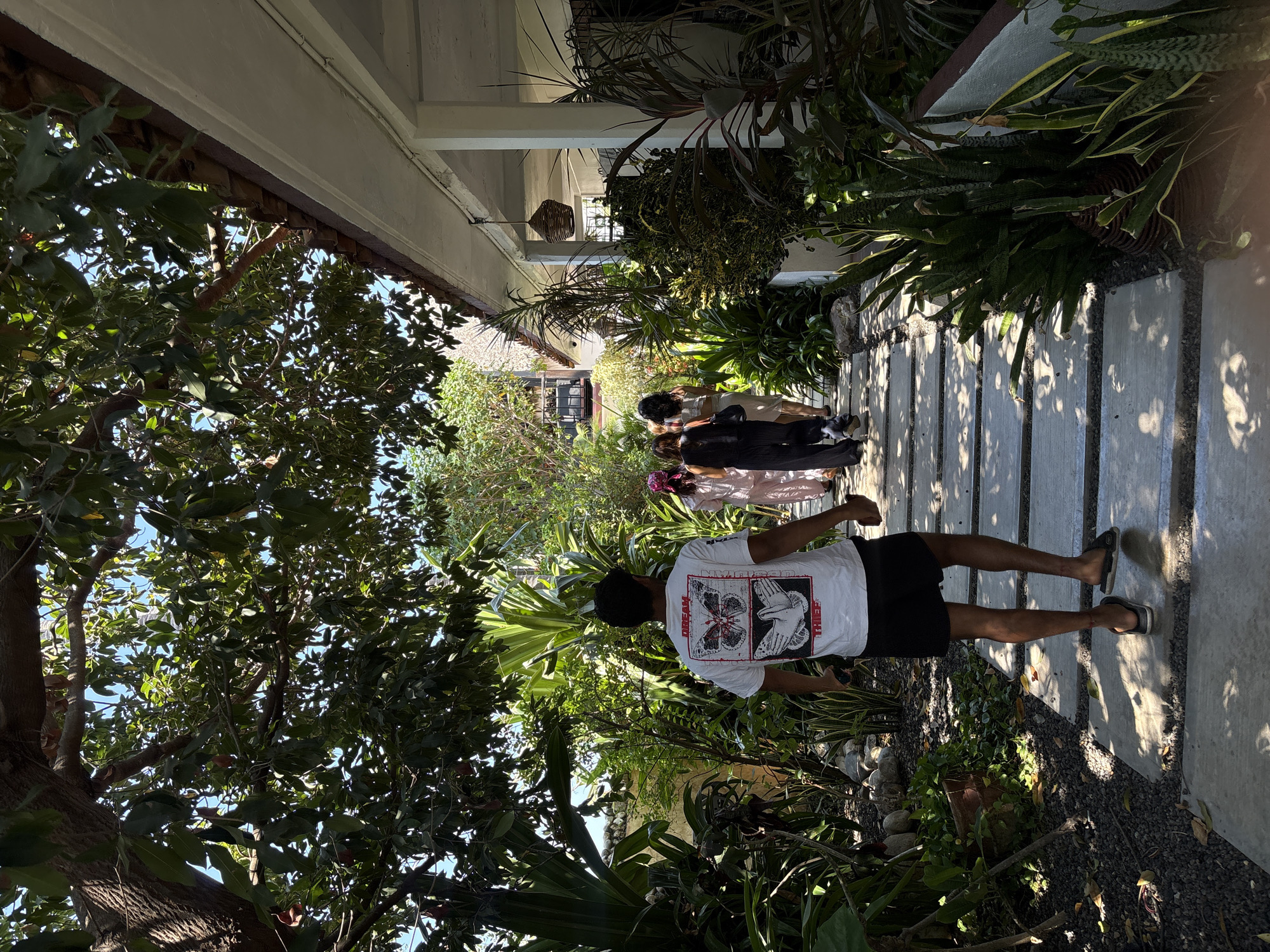 Visitors stroll through tropical garden pathway in Puerto Escondido