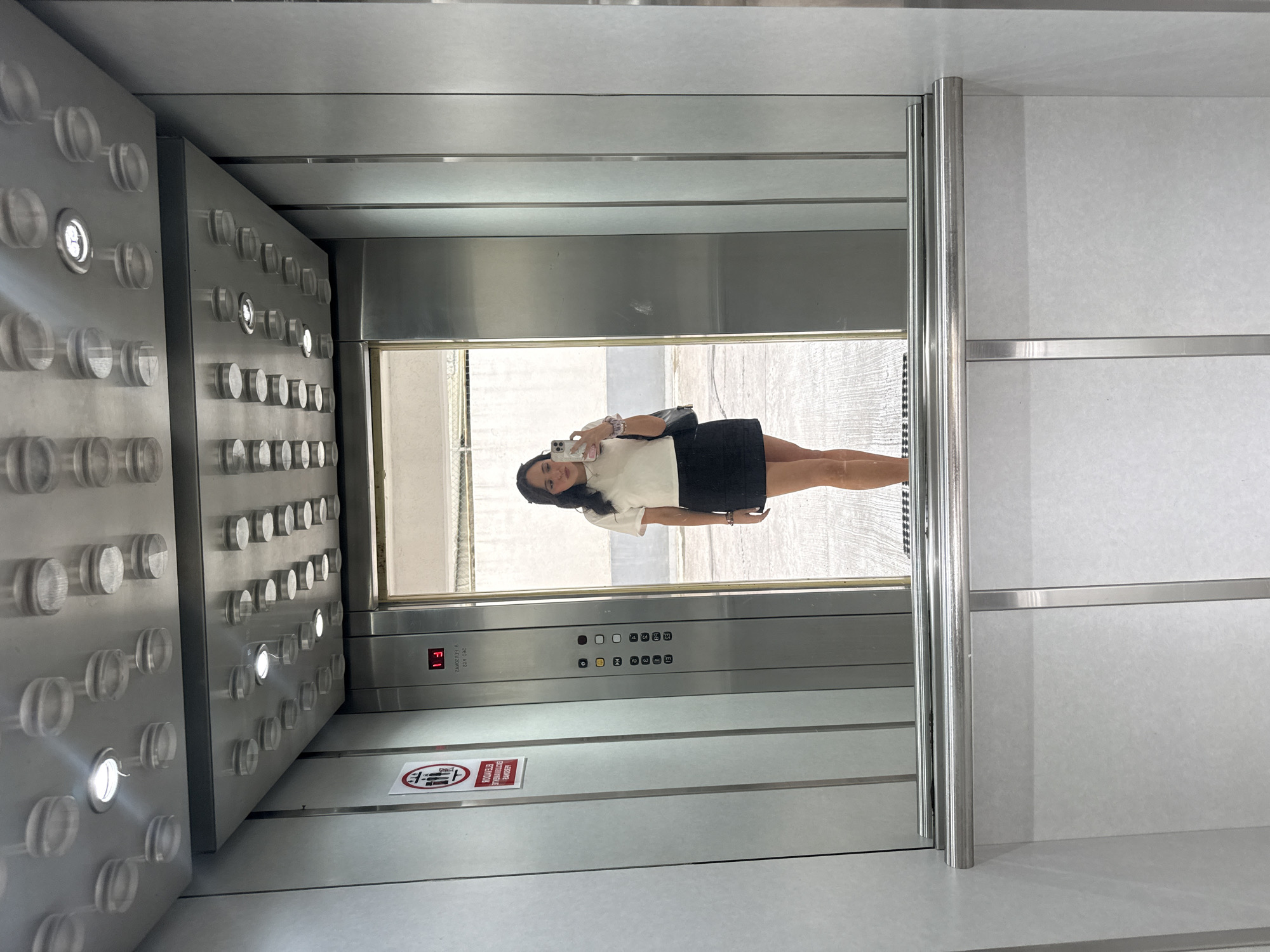 Woman takes selfie in modern Mexico City elevator