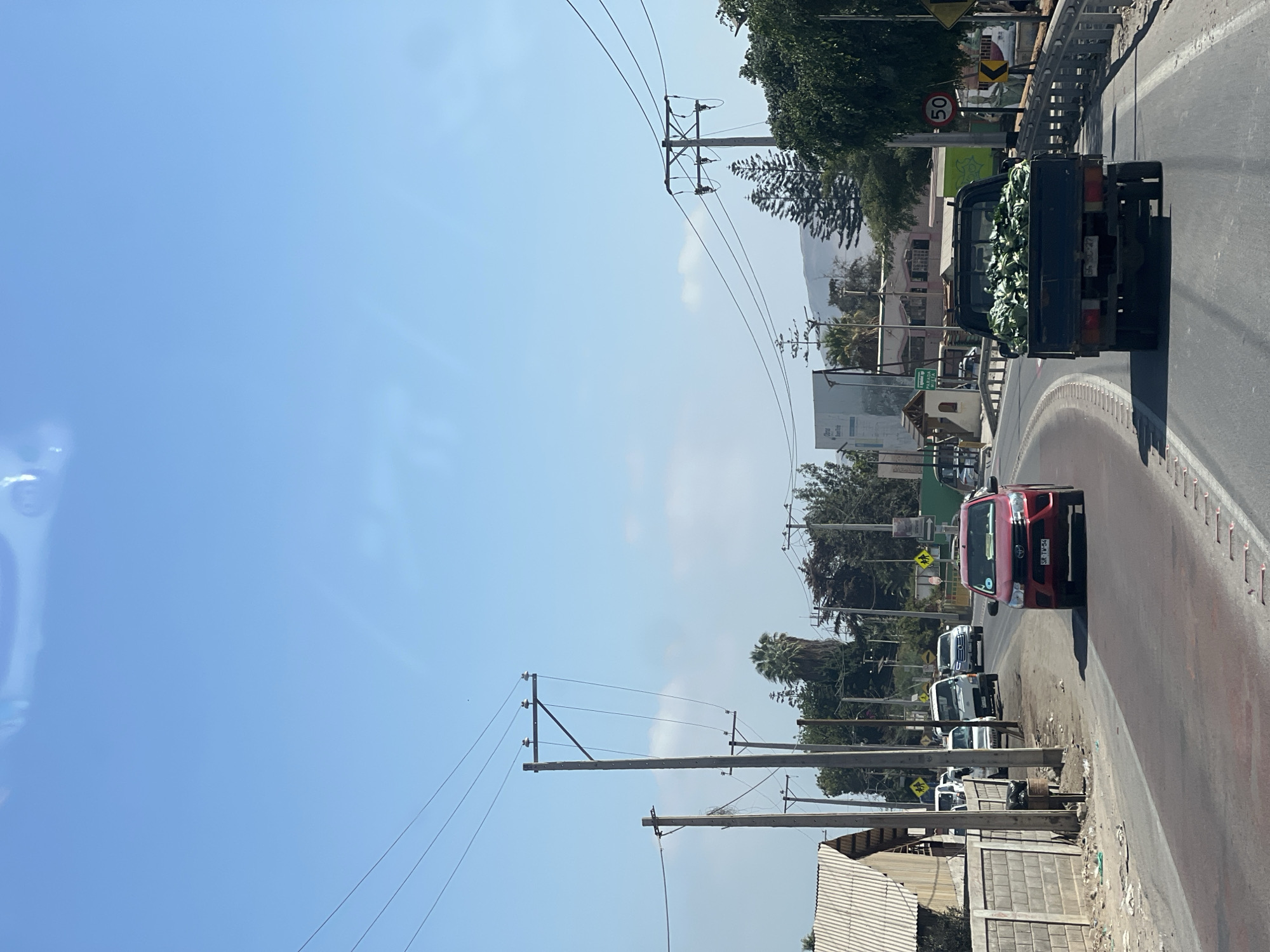 Vehicles spotted on sunny Arica street, truck carrying vegetables