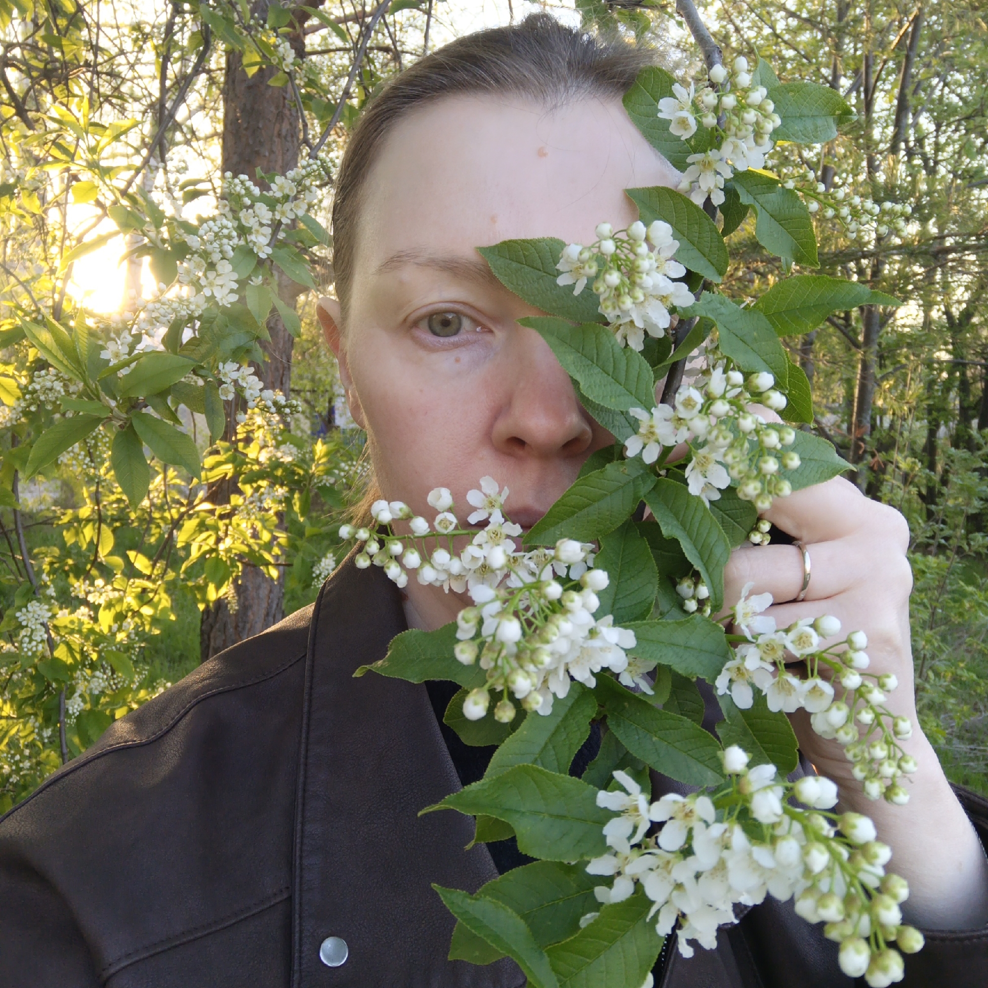 Person poses with white blossoms in Chaikovsky, Russia