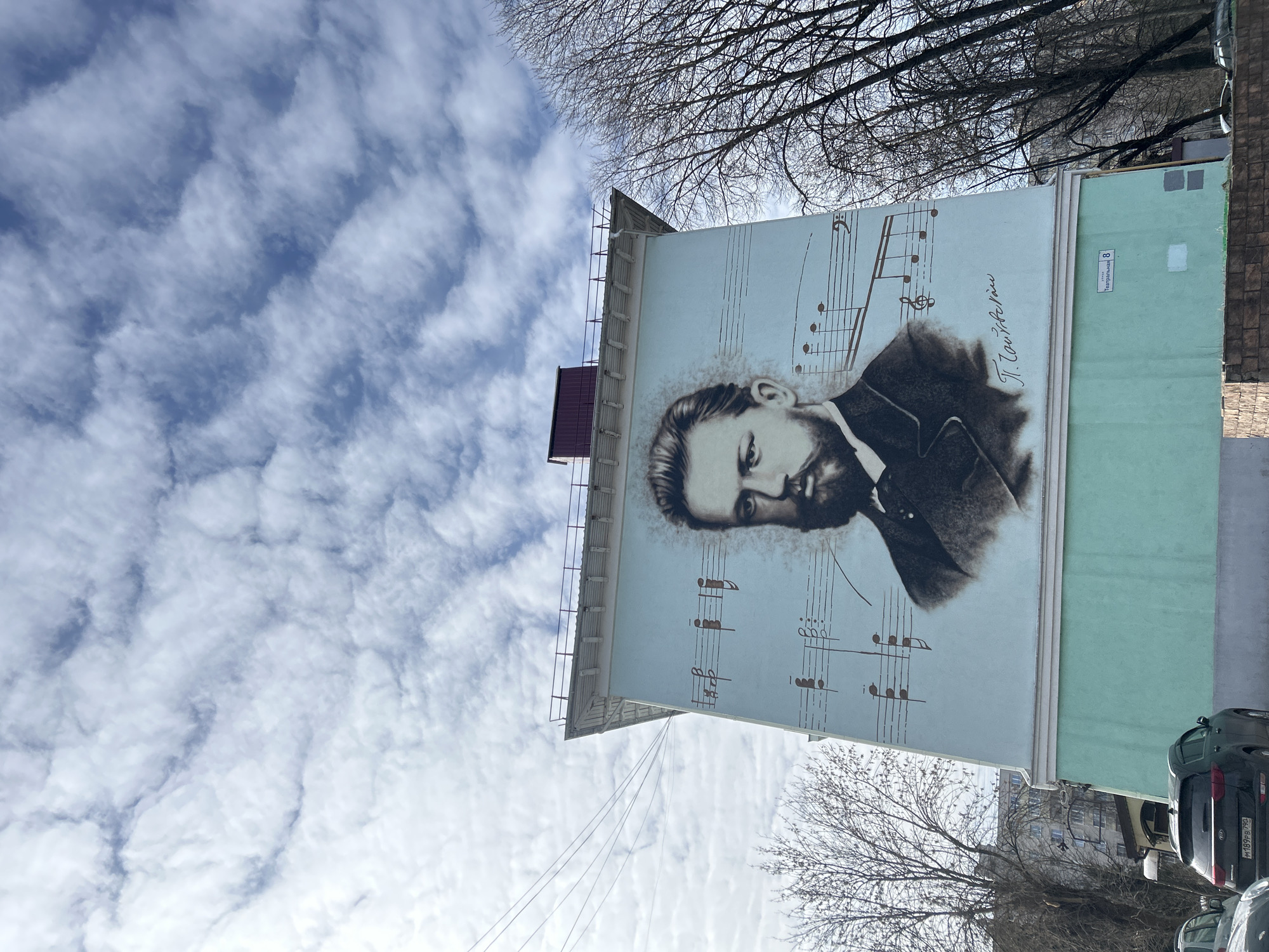 Woman photographed multiple times in Klin alongside Tchaikovsky mural