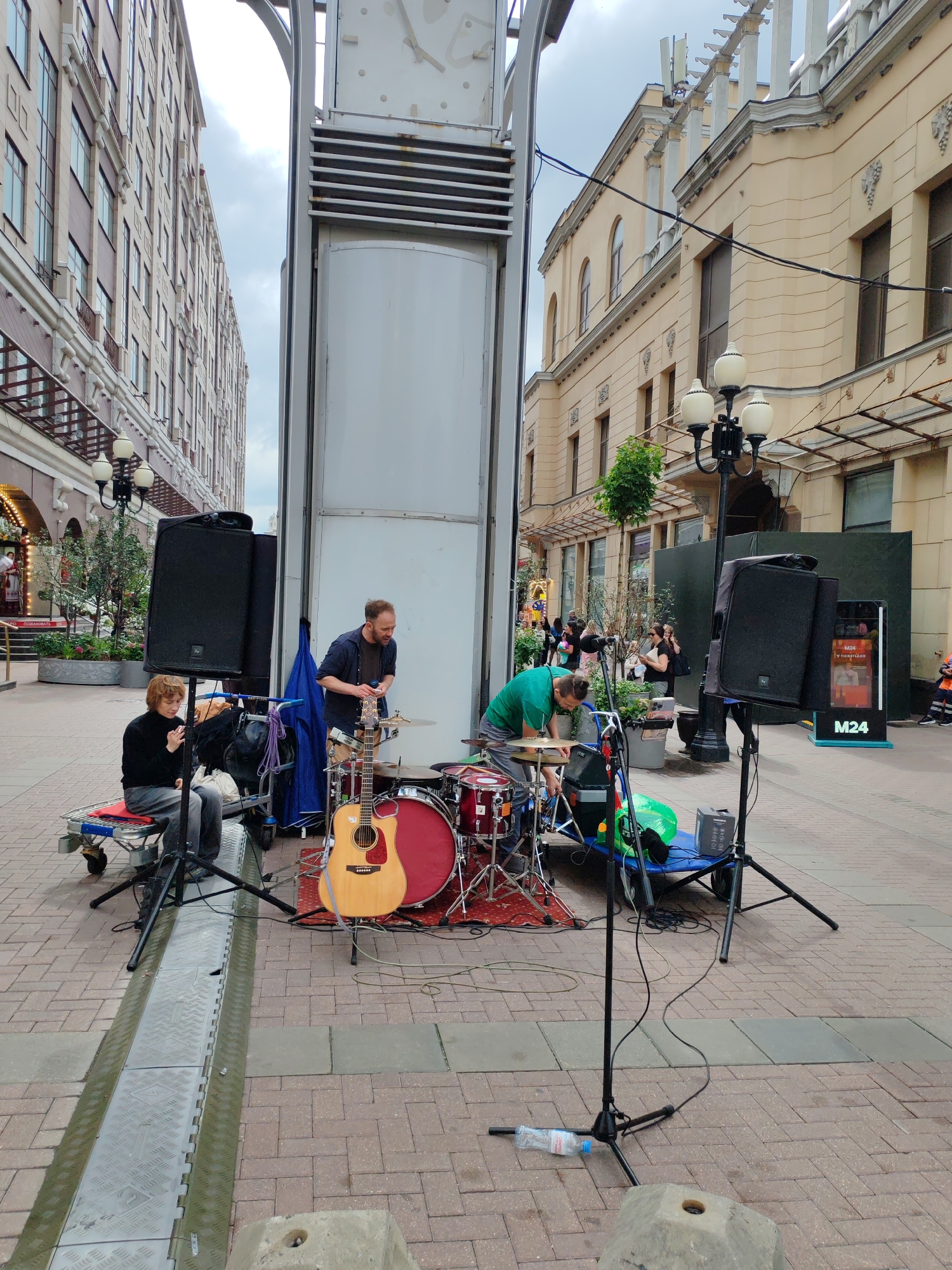 Street-level city life: music, pedestrians, and wet pavement