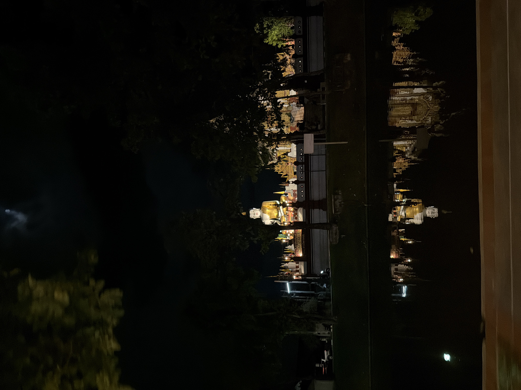 Illuminated golden Buddha statue at night in Chiang Mai