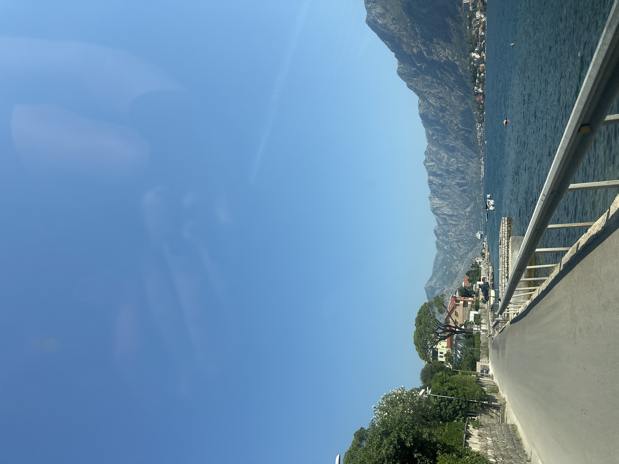 Sunny coastal road hugging the Bay of Kotor in Muo