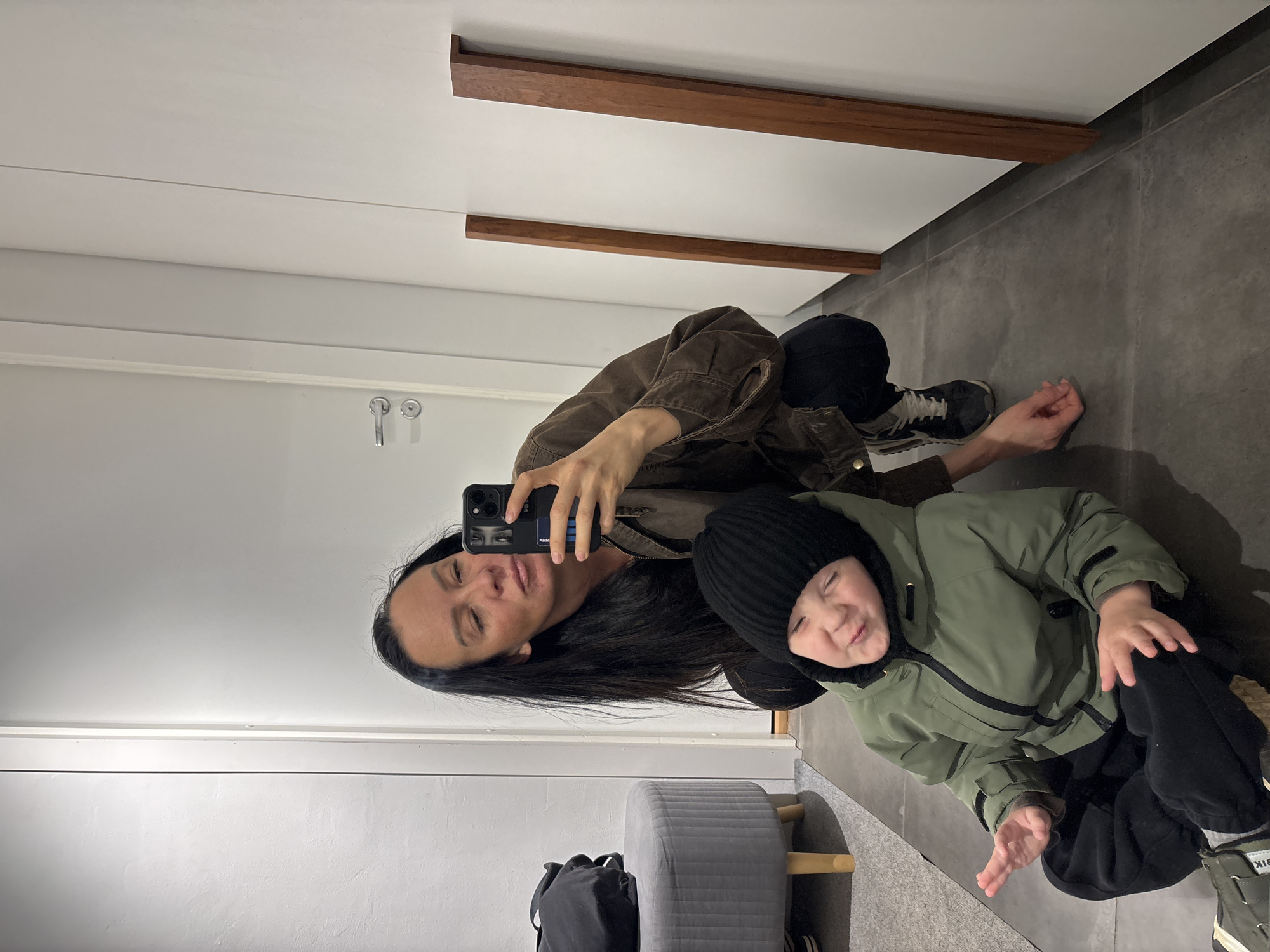 Woman takes mirror selfie with child in Chaikovsky