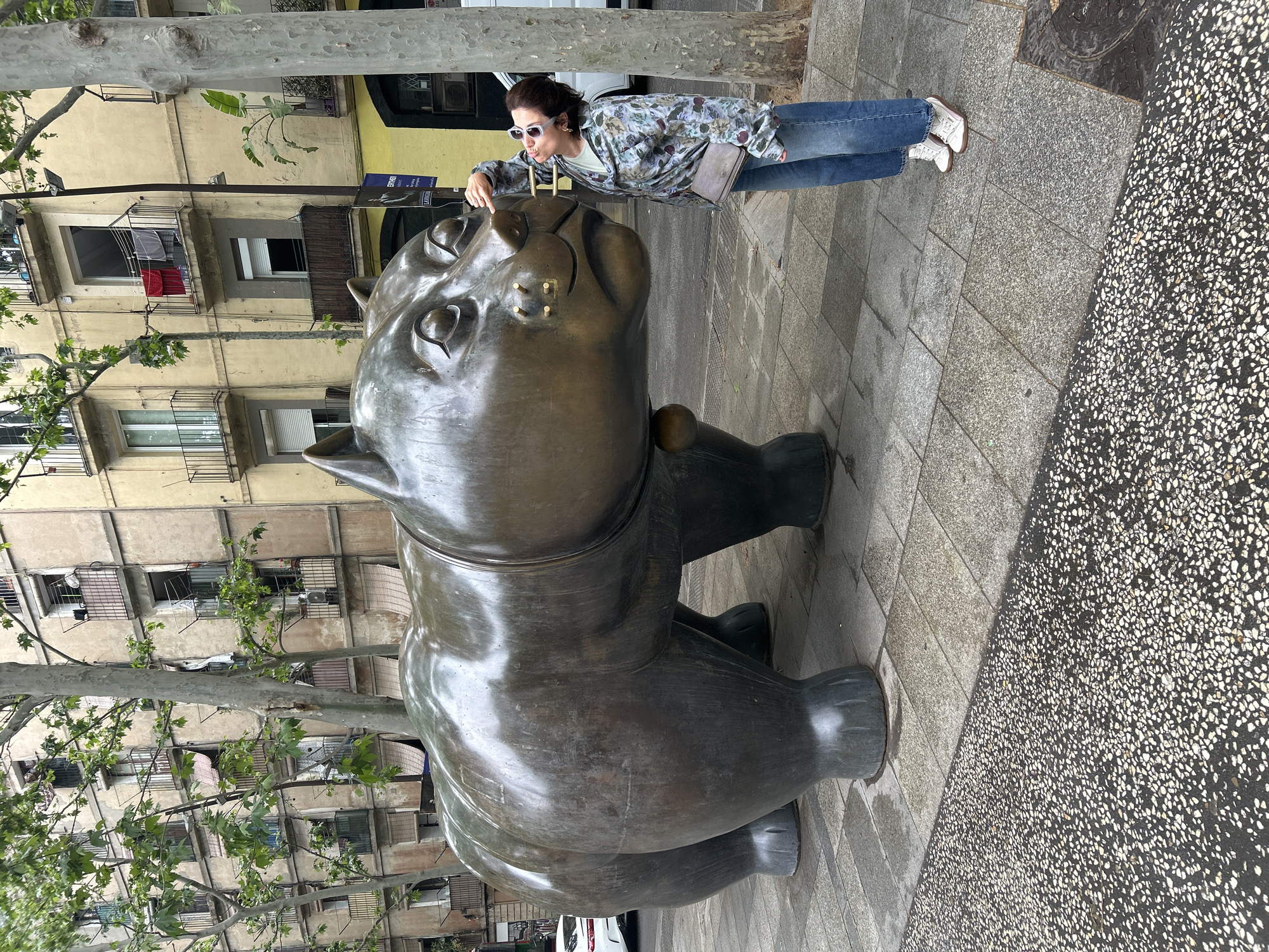Tourist interacts with Botero cat sculpture in Barcelona