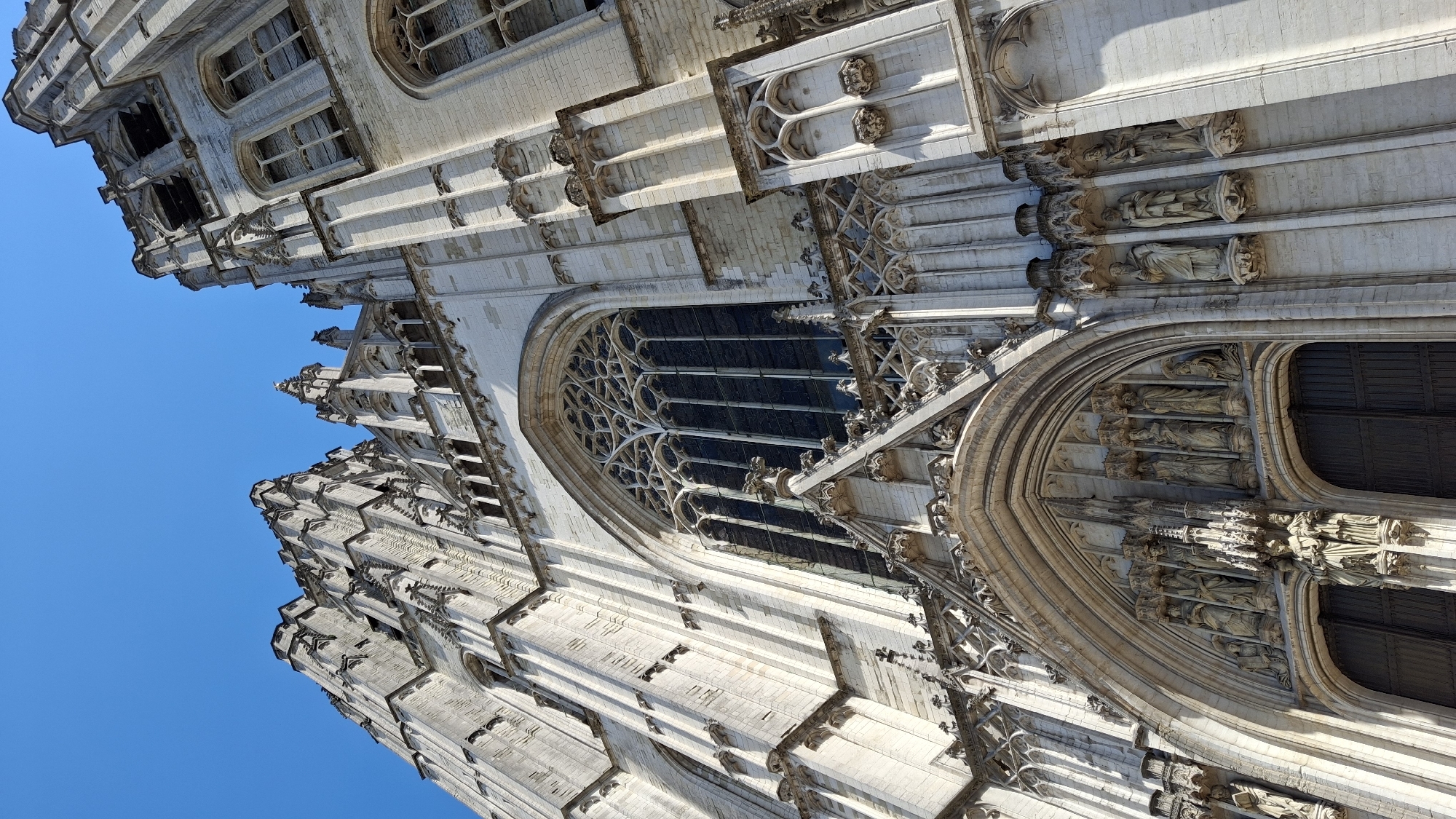 Inside a grand Gothic cathedral, statues, glass, and stone.
