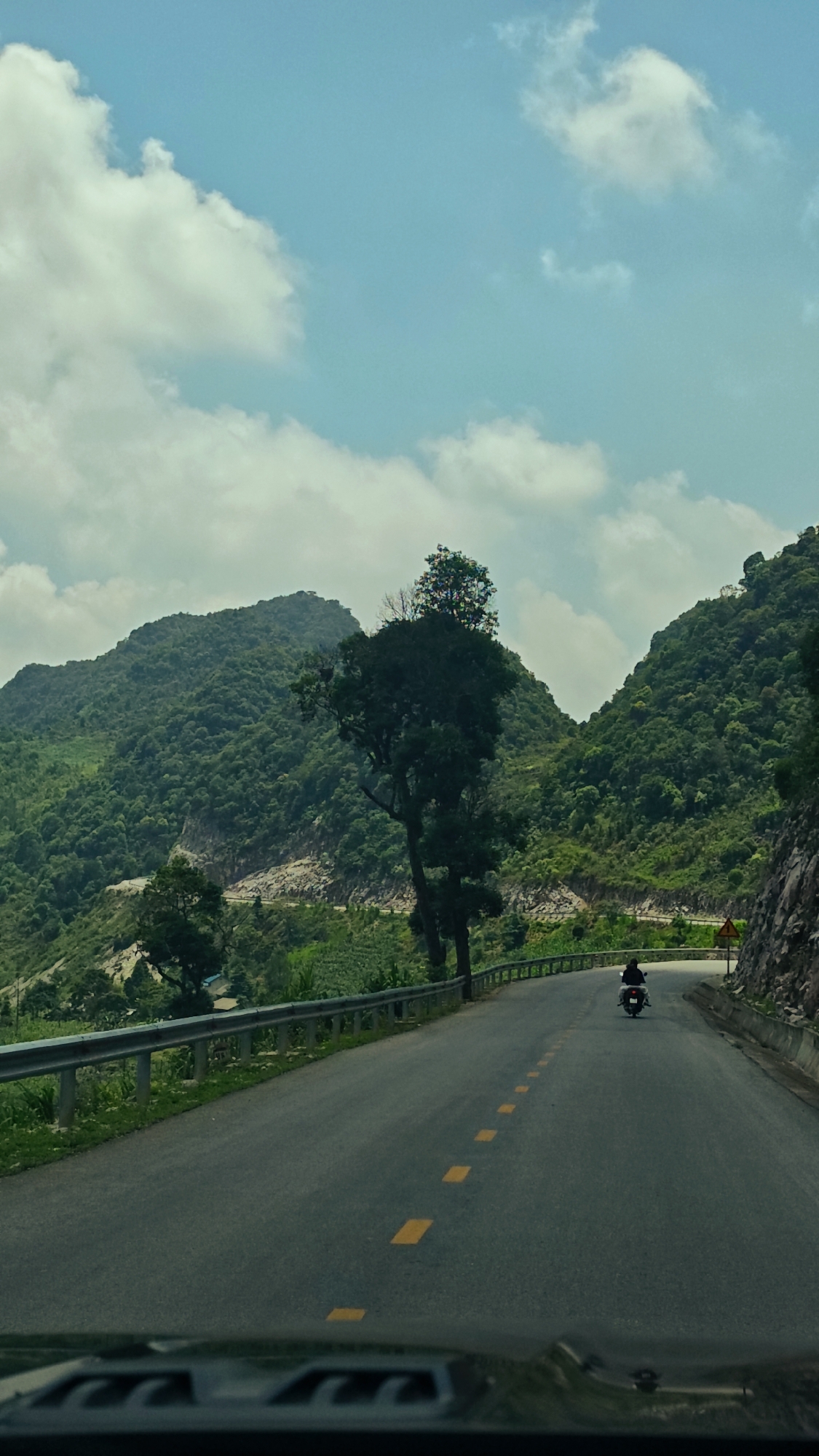 Motorcycle travels mountain road through northern Vietnam communes