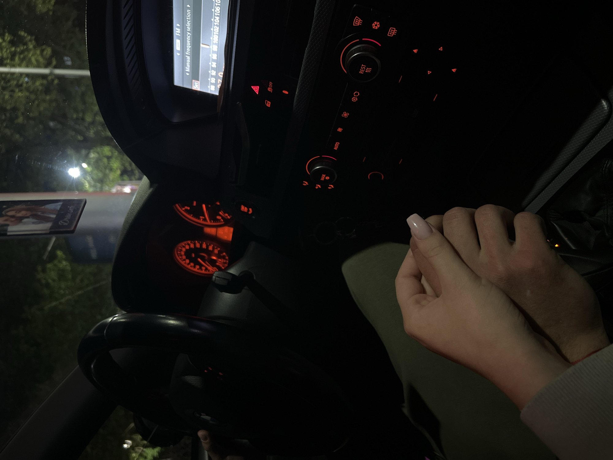 Couple holds hands inside BMW at night in Plovdiv