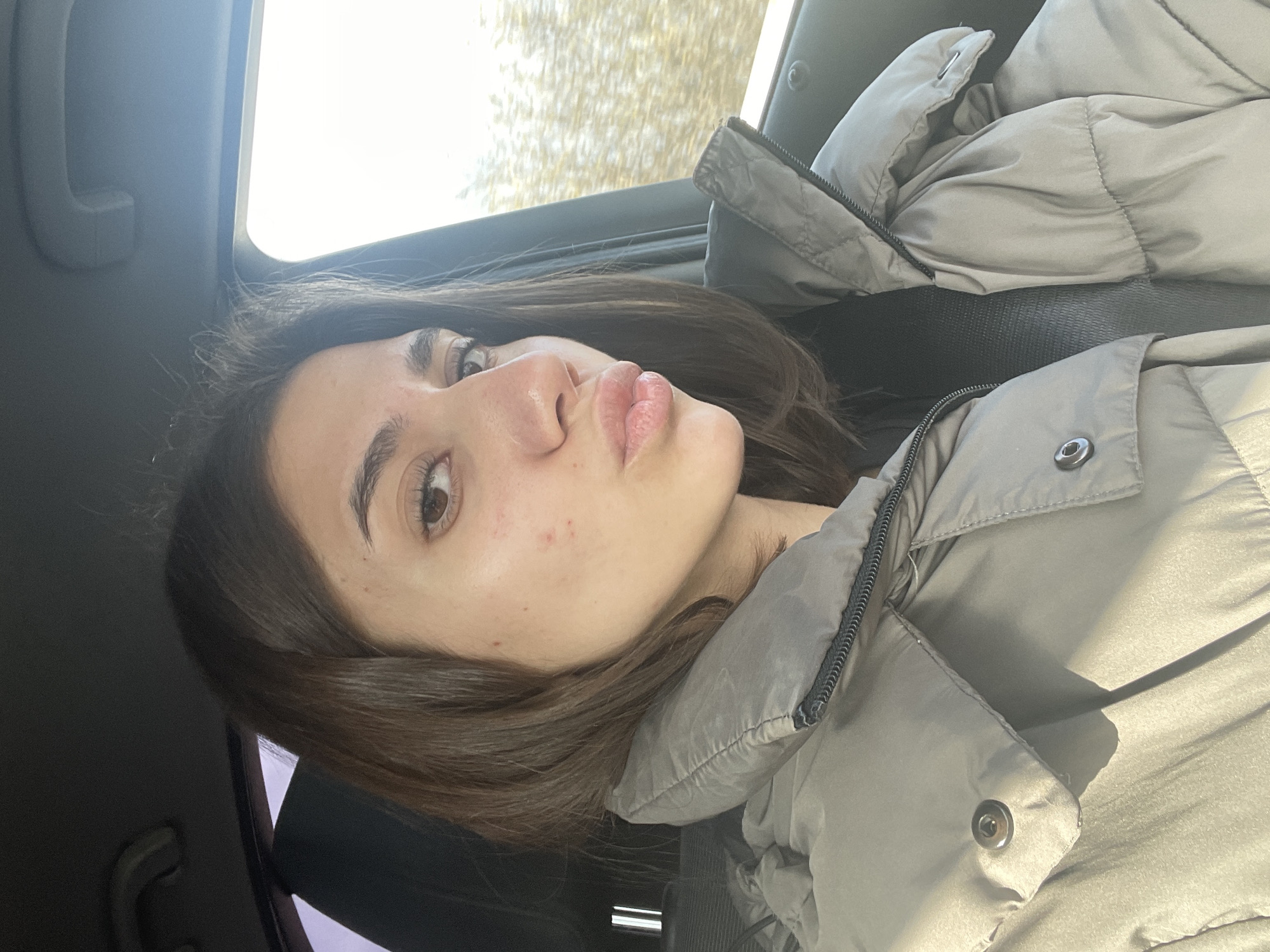 Woman poses for selfie in car passenger seat in Sofia