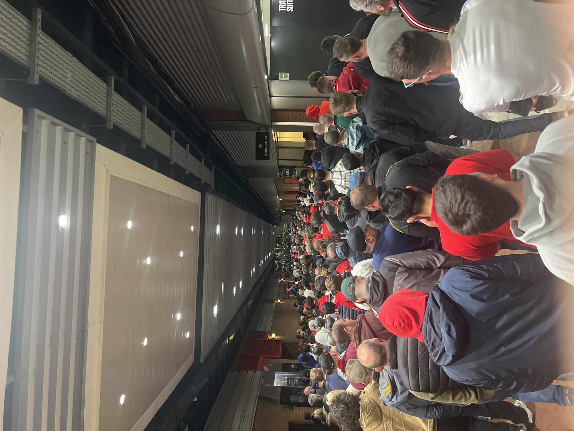 Large crowd moves through Trafford stadium concourse