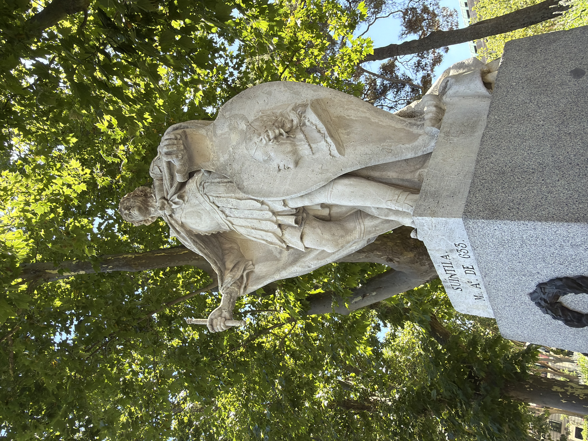 Historic stone statues in a sunny Madrid park