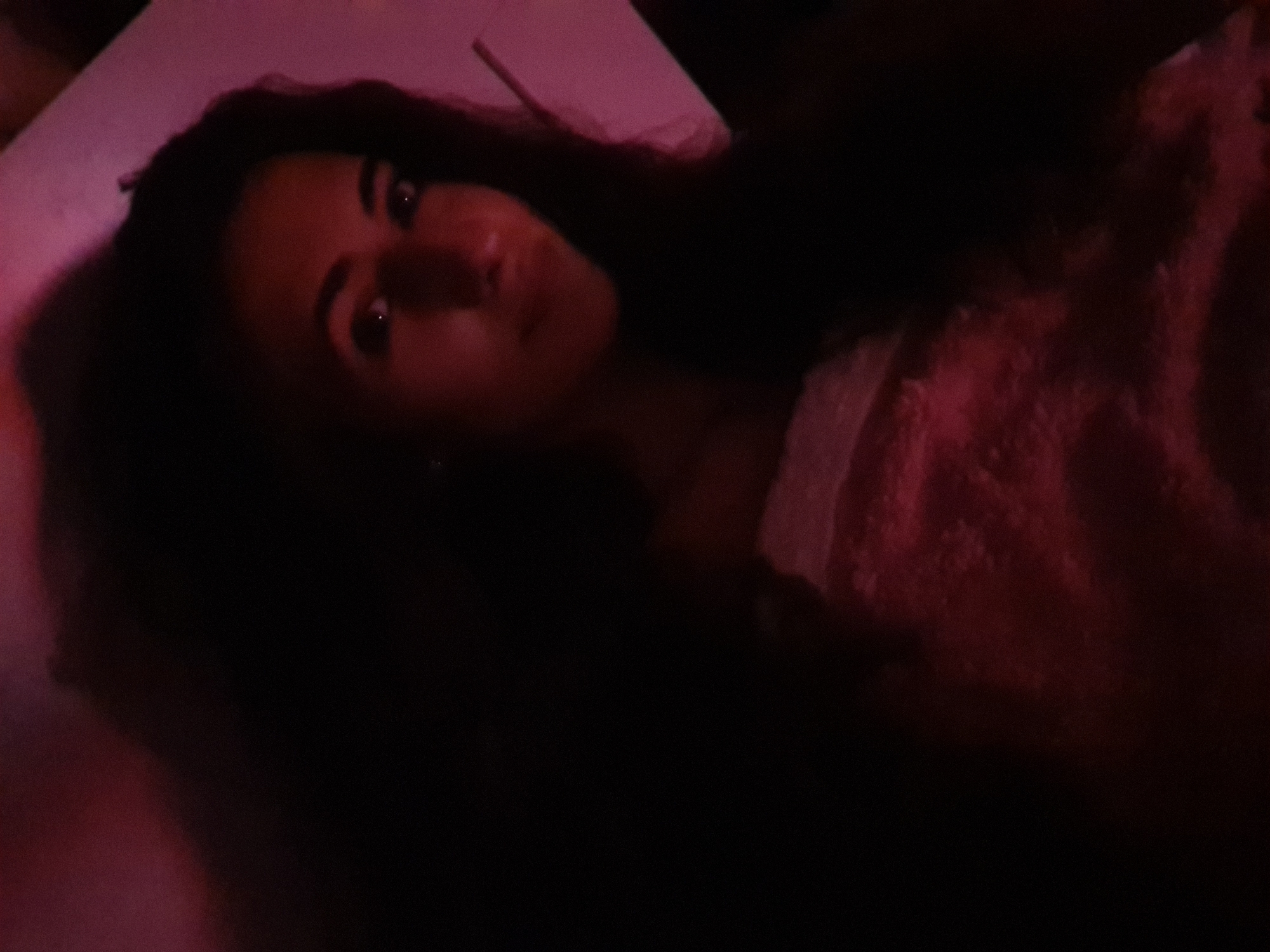 Person relaxes in darkened room with screen light