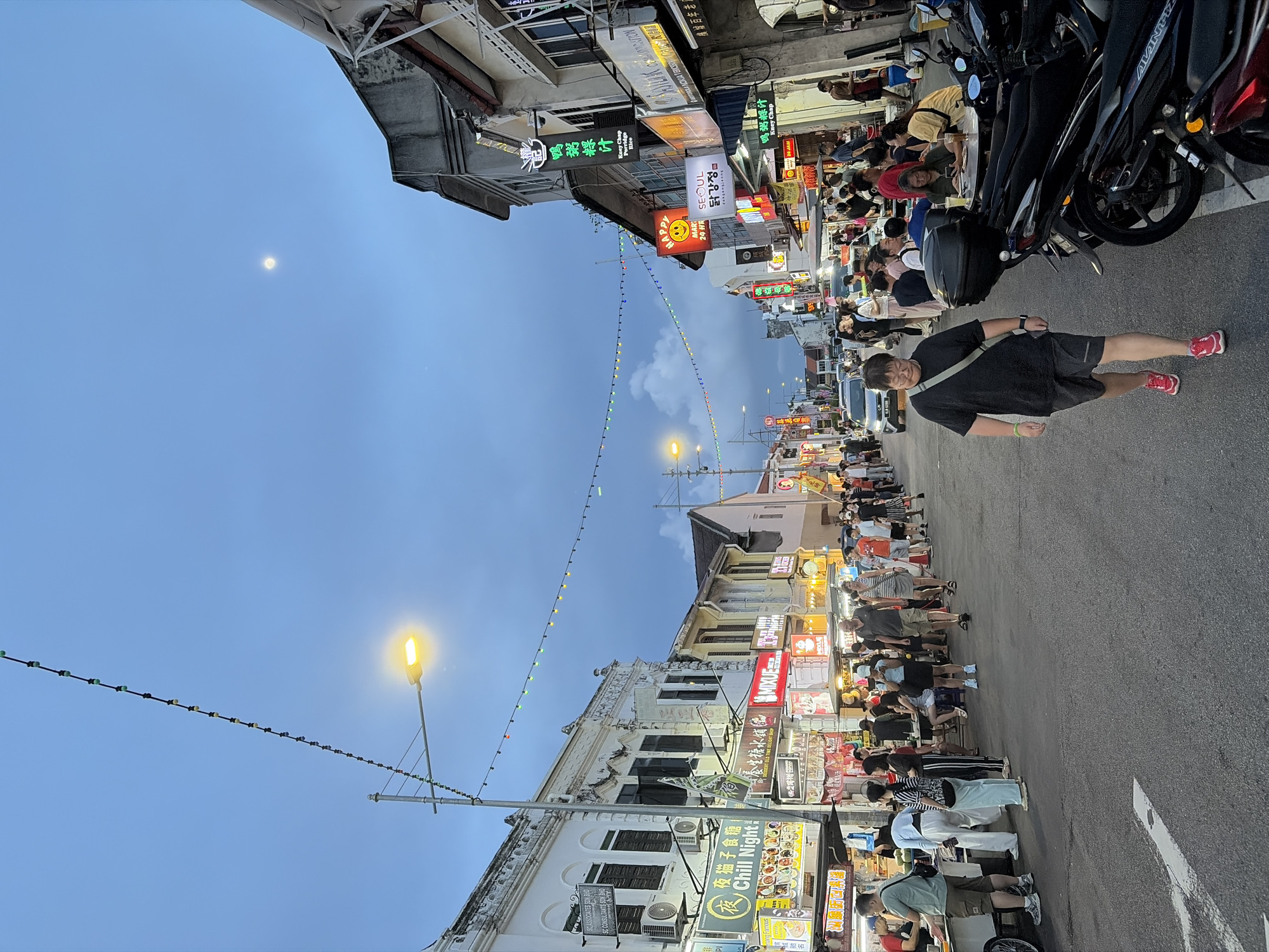 Southeast Asian street scene comes alive at dusk with food and traffic
