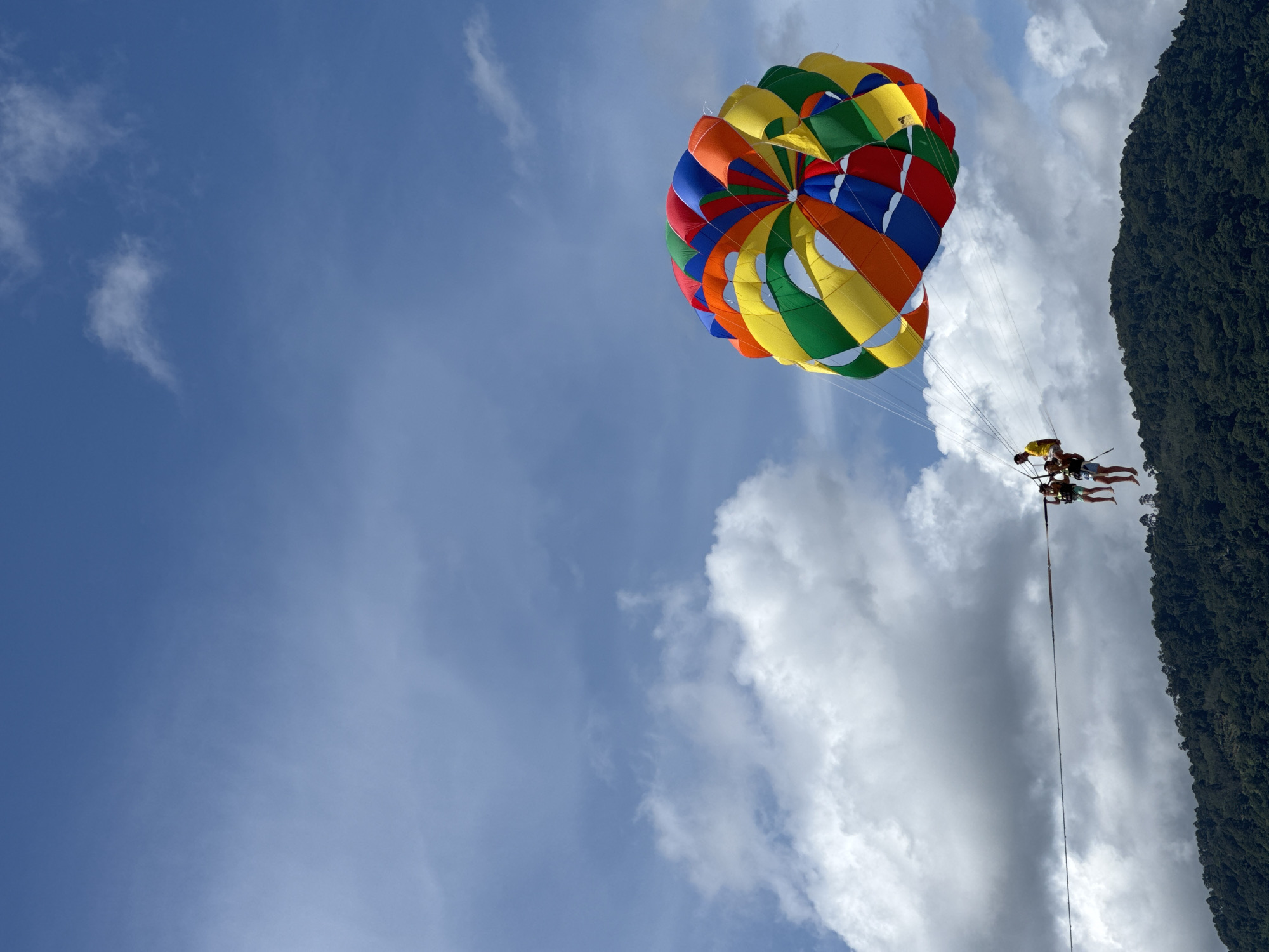 Parasailing and beach activity on a busy Patong morning