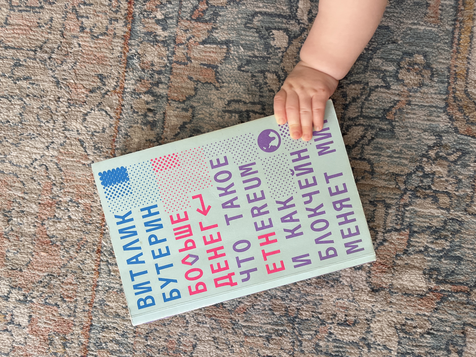 Limassol resident examines Russian Ethereum book with baby present