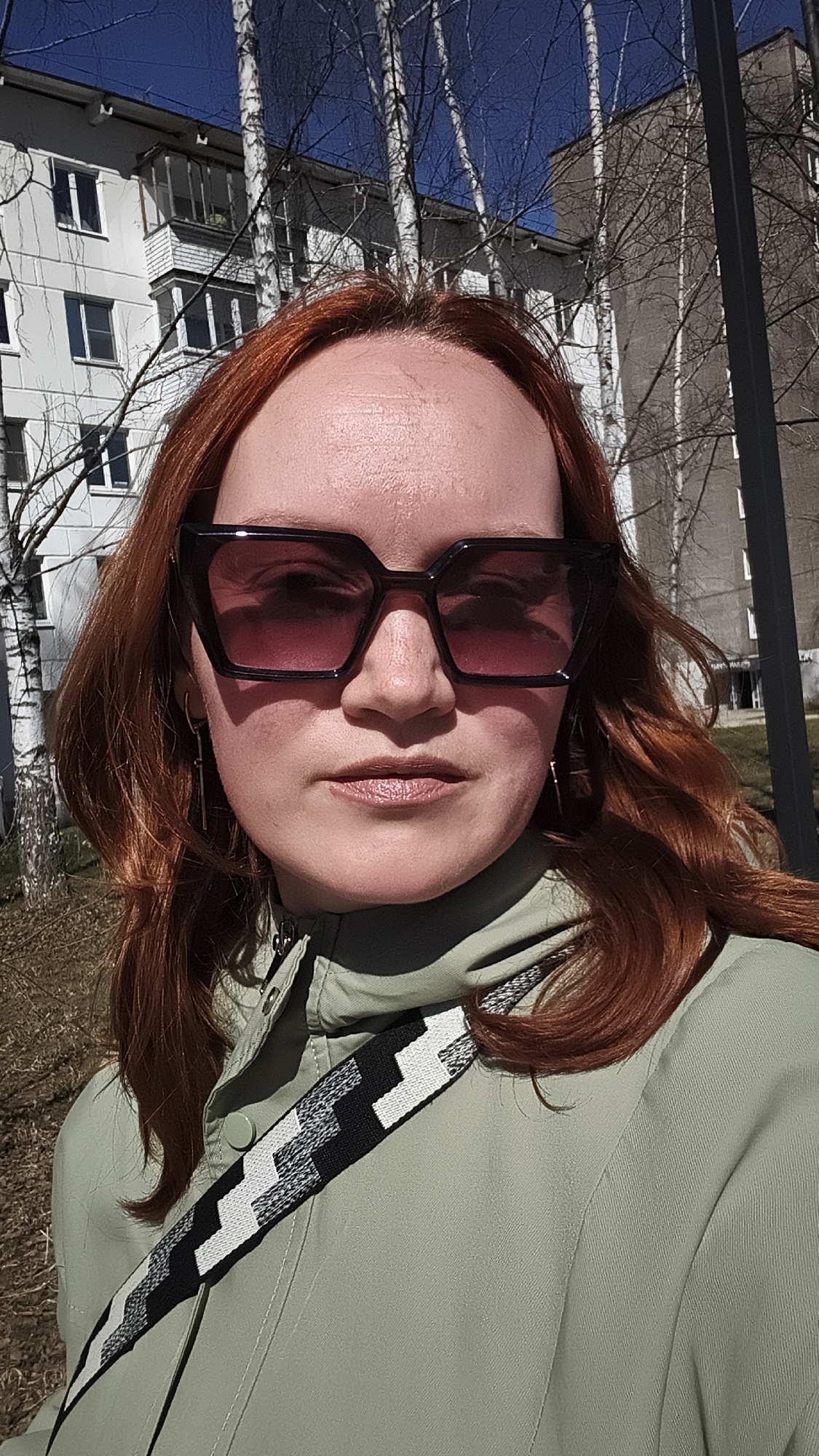 Woman takes selfie near blooming coltsfoot flowers in Chaikovsky