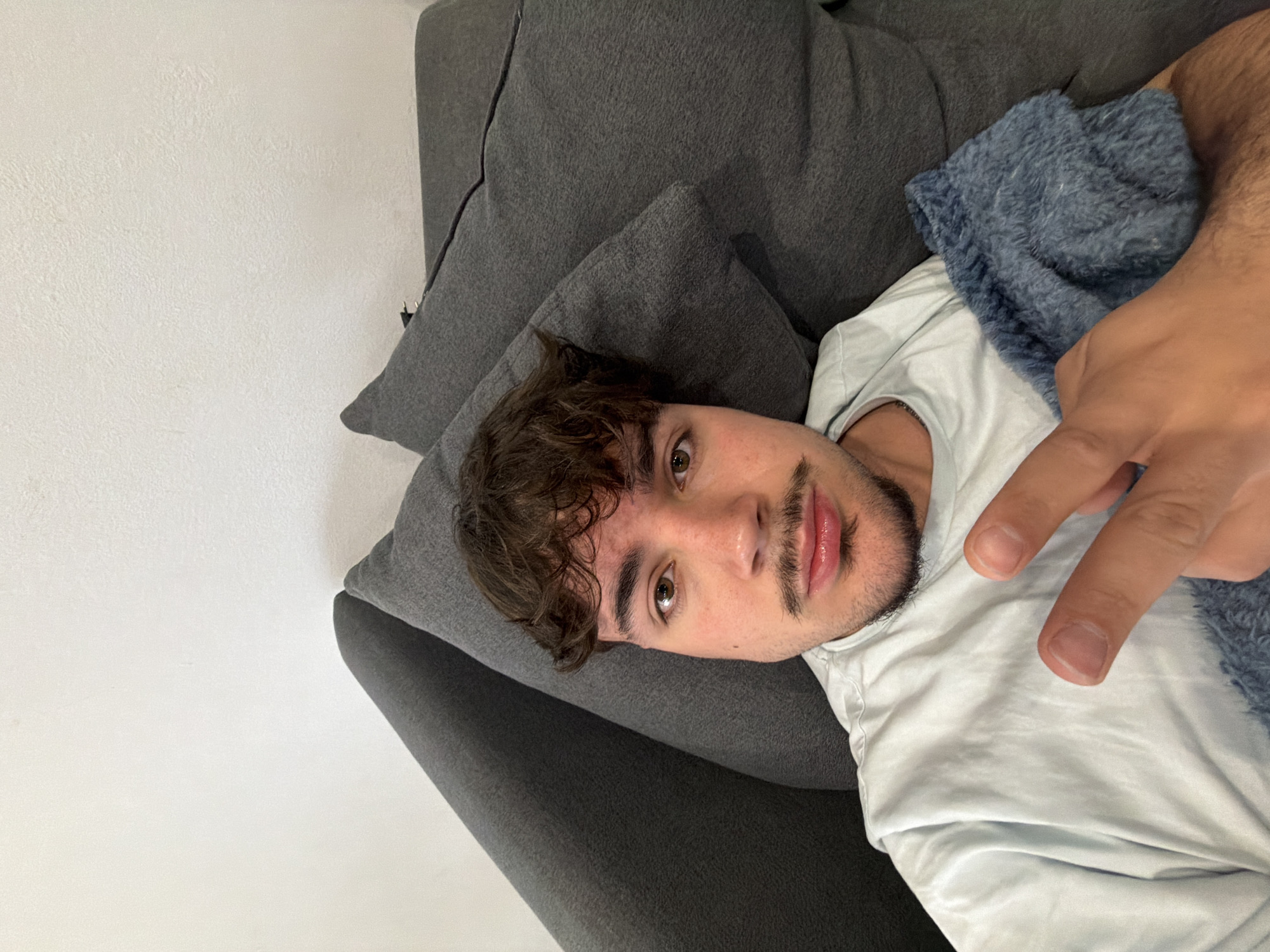 Young man takes casual selfies on couch in Rijeka