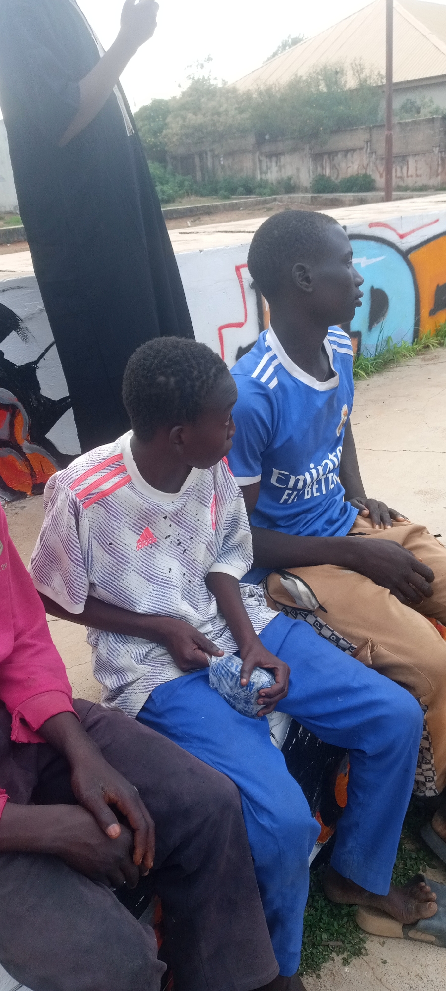 Young people gather at colorful outdoor basketball court for recreation