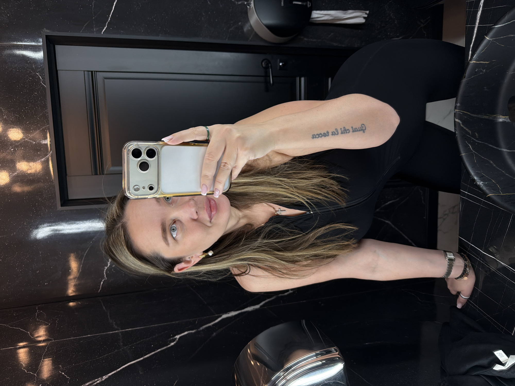 Woman takes bathroom selfies in black marble Moscow restroom
