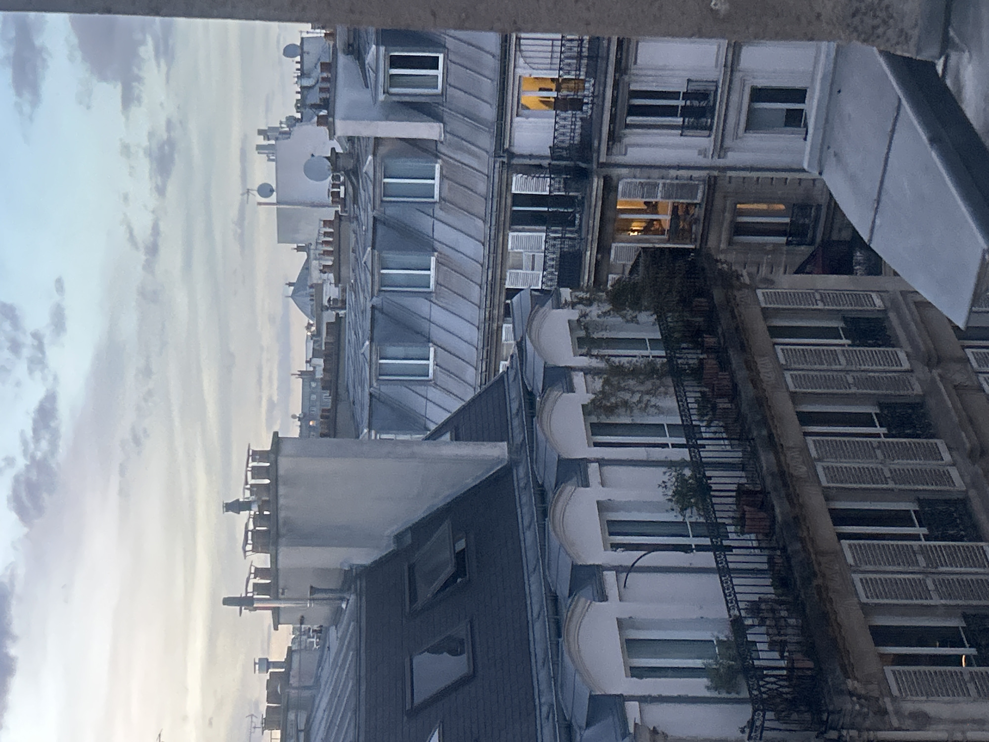 Witness documents dusk transition over European city rooftops