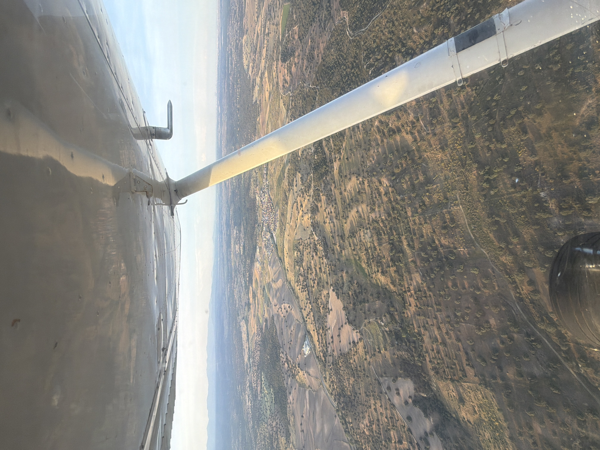 Aircraft flies over Villamantilla countryside in evening flight