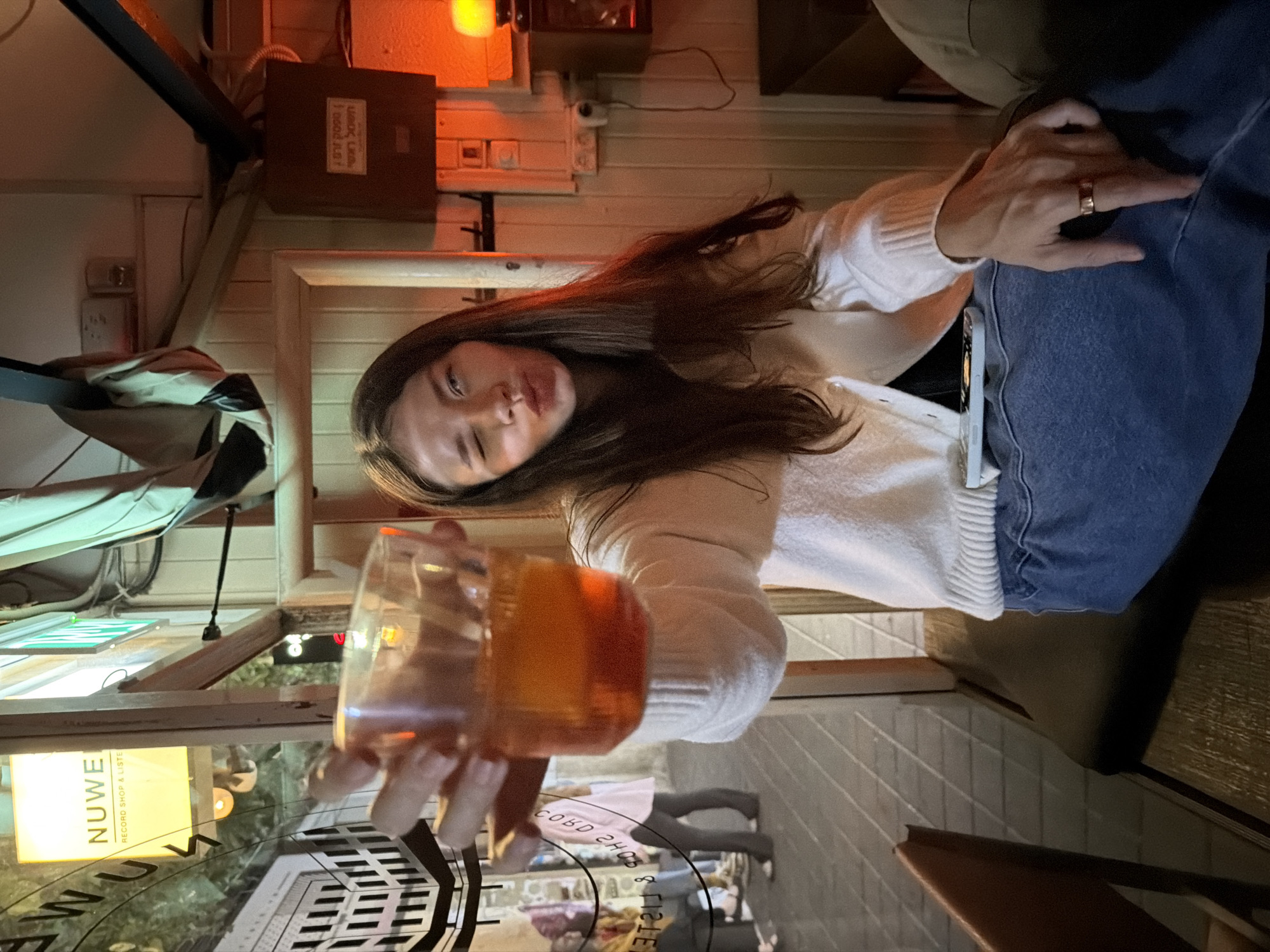 Woman raises glass in vintage bar setting