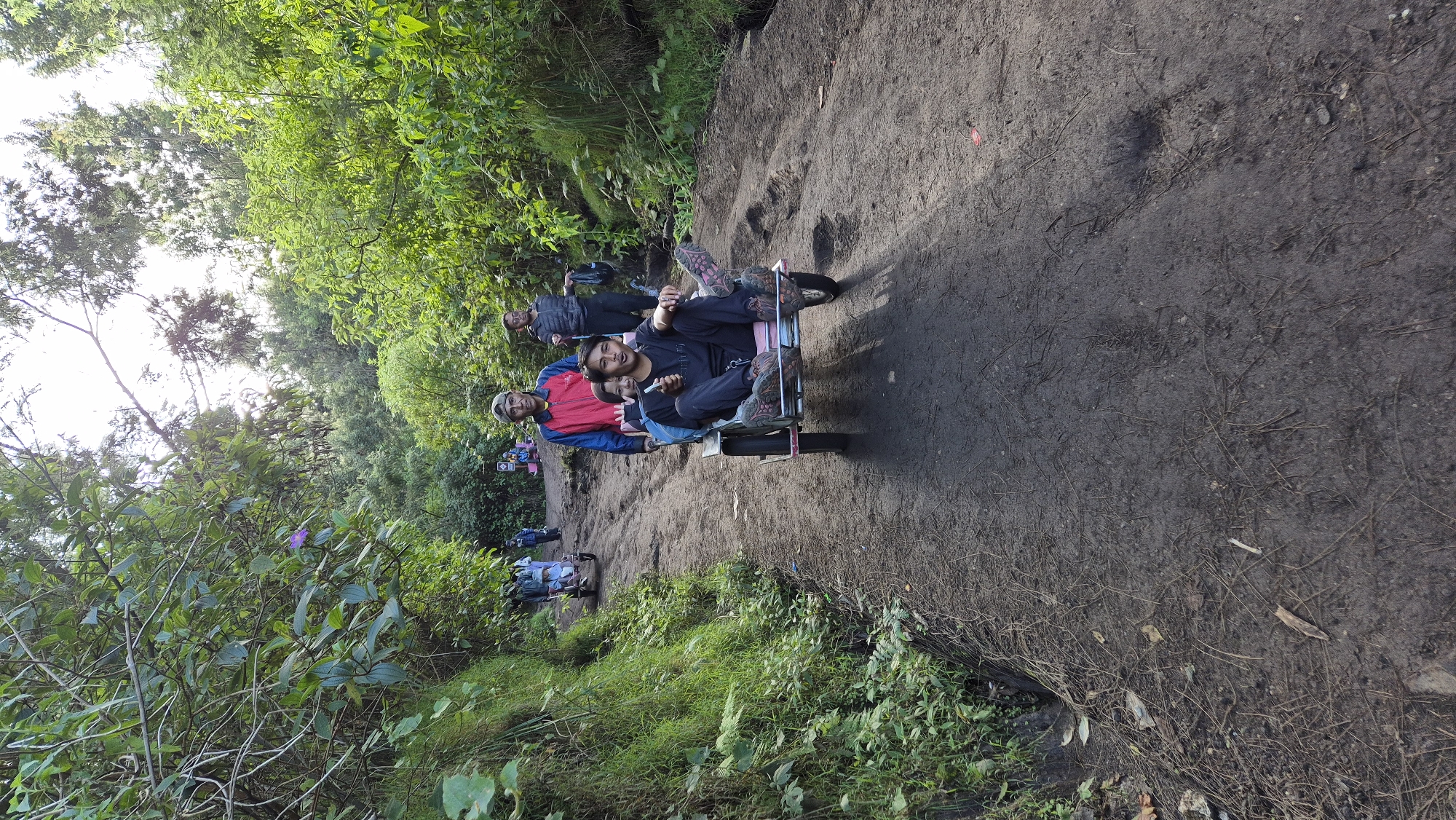 Cart travelers navigate muddy forest path in Indonesia