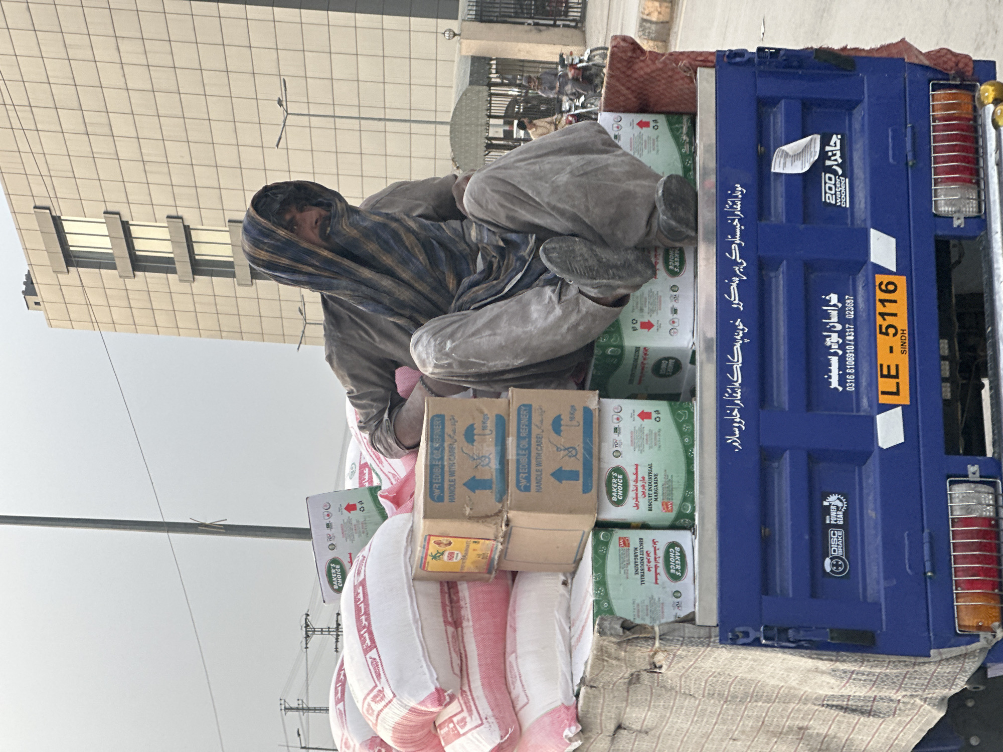 Man sits atop cargo truck in Quetta, Pakistan