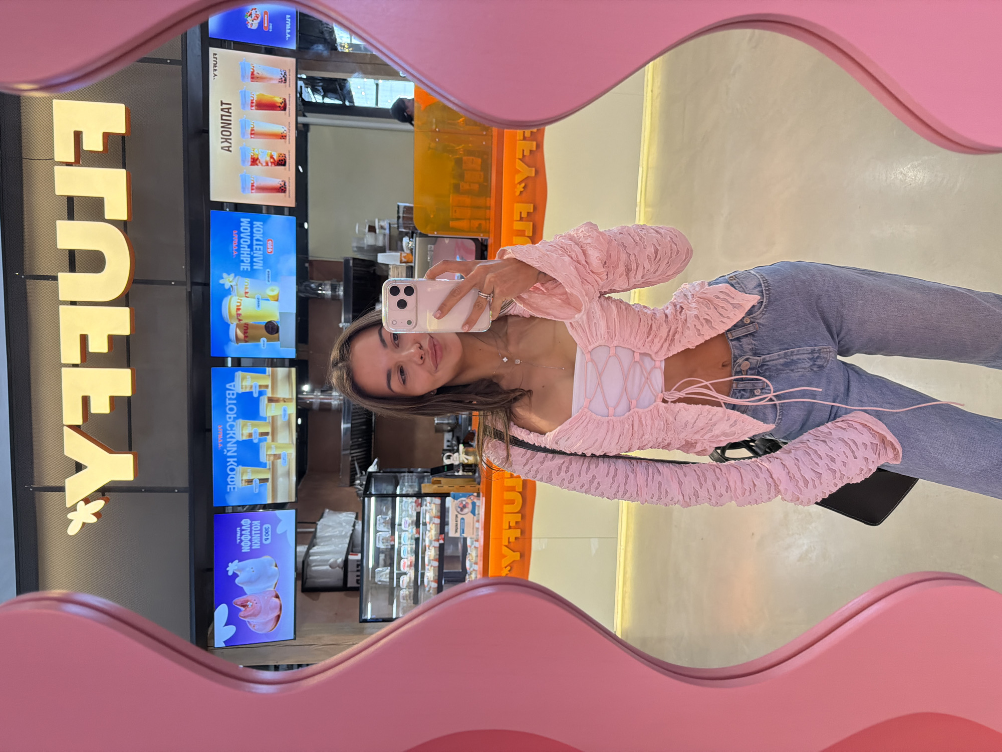 Woman takes mirror selfie at Krasnoyarsk cafe