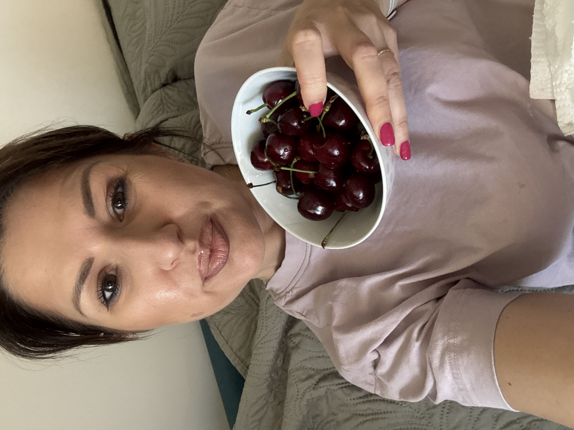 Woman enjoys fresh cherries indoors in Sofia