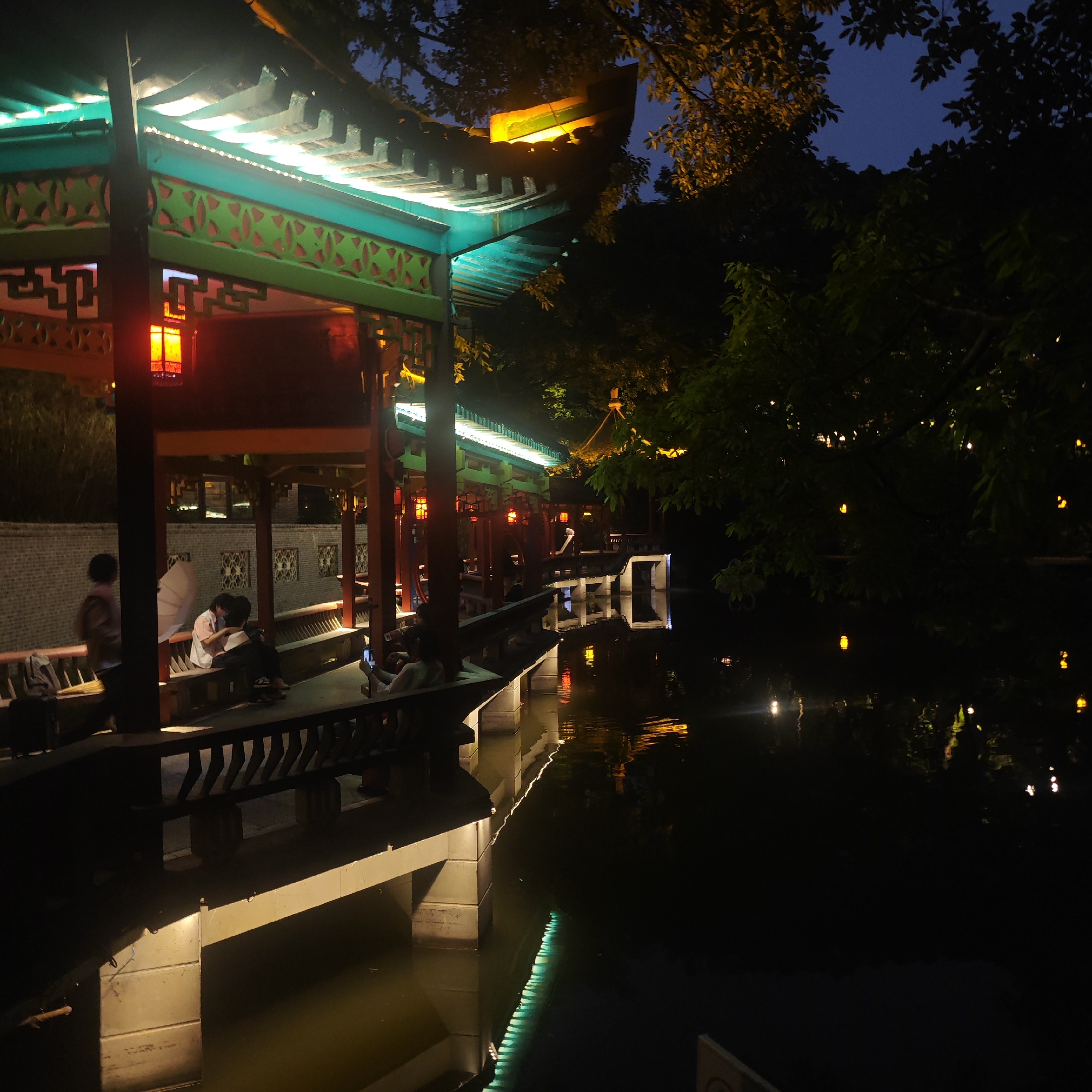 Nighttime social gathering observed in Yuzhong District waterside pavilion