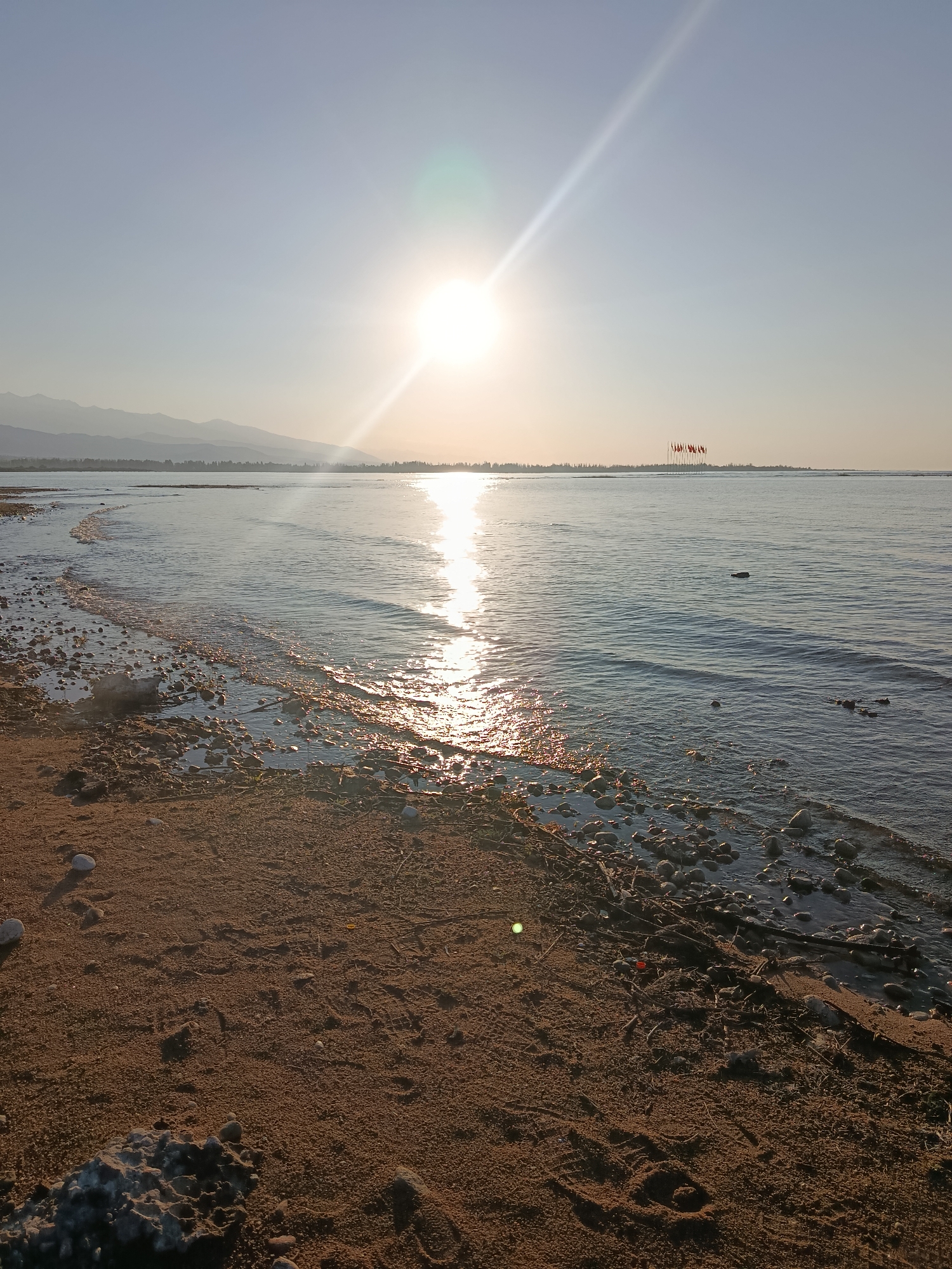 Calm lakeside sunset on a rocky beach in Kyrgyzstan