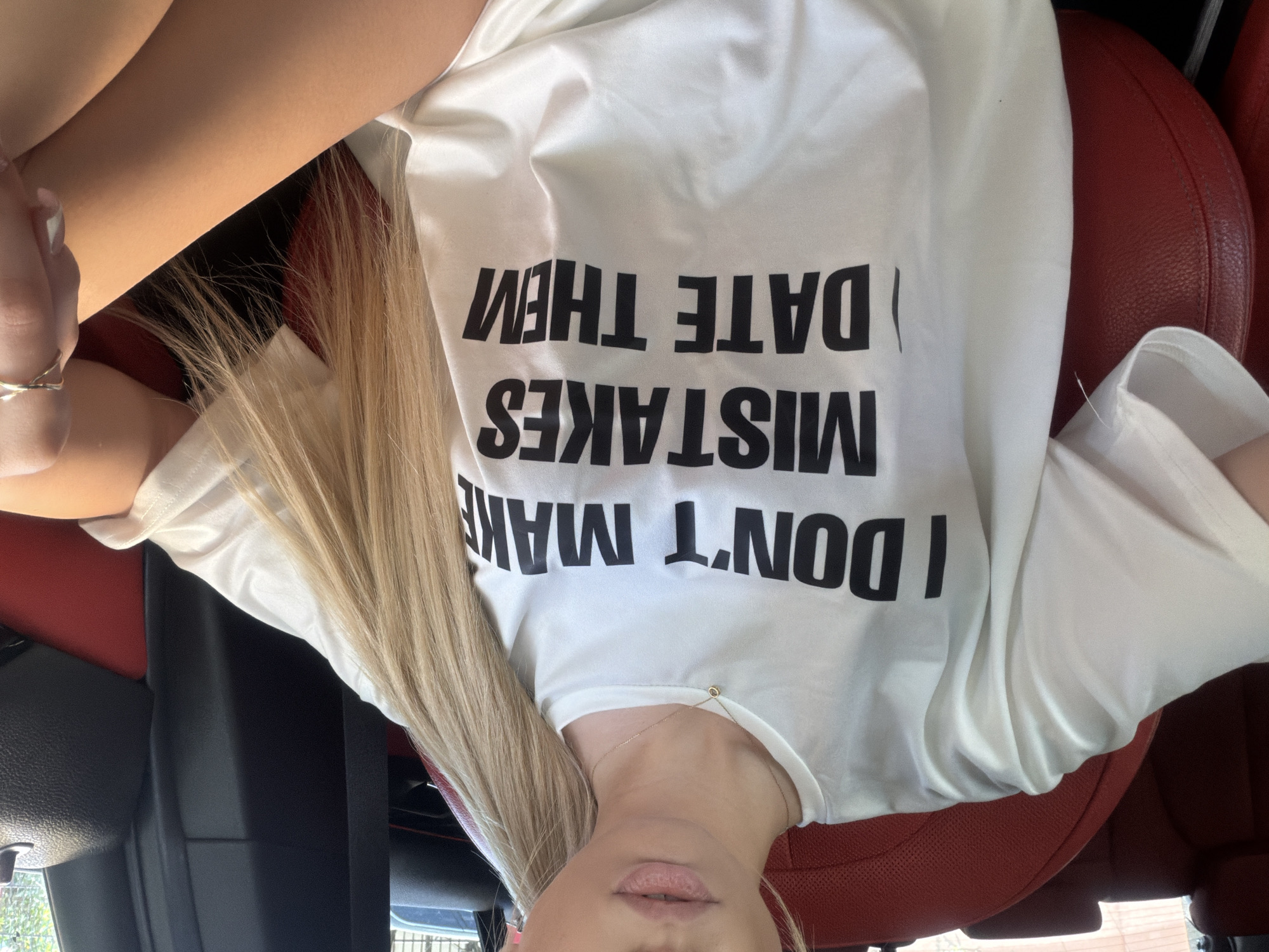 Woman in humorous t-shirt spotted in car passenger seat