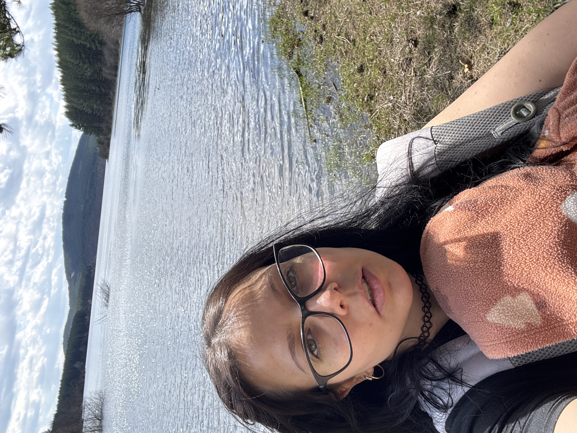 Woman takes selfie at scenic Bulgarian lake surrounded by forest
