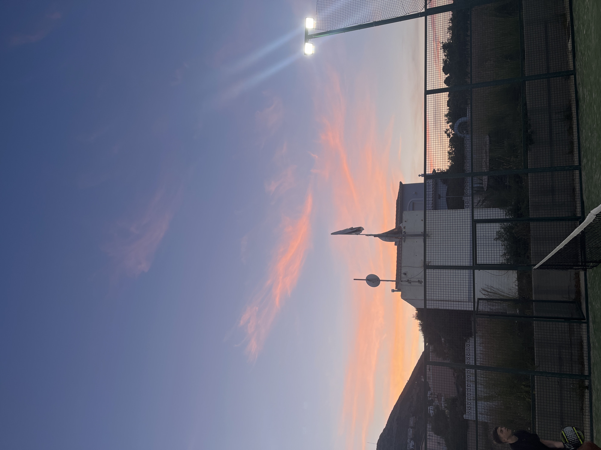 Evening paddle tennis match captured at Spanish coastal town