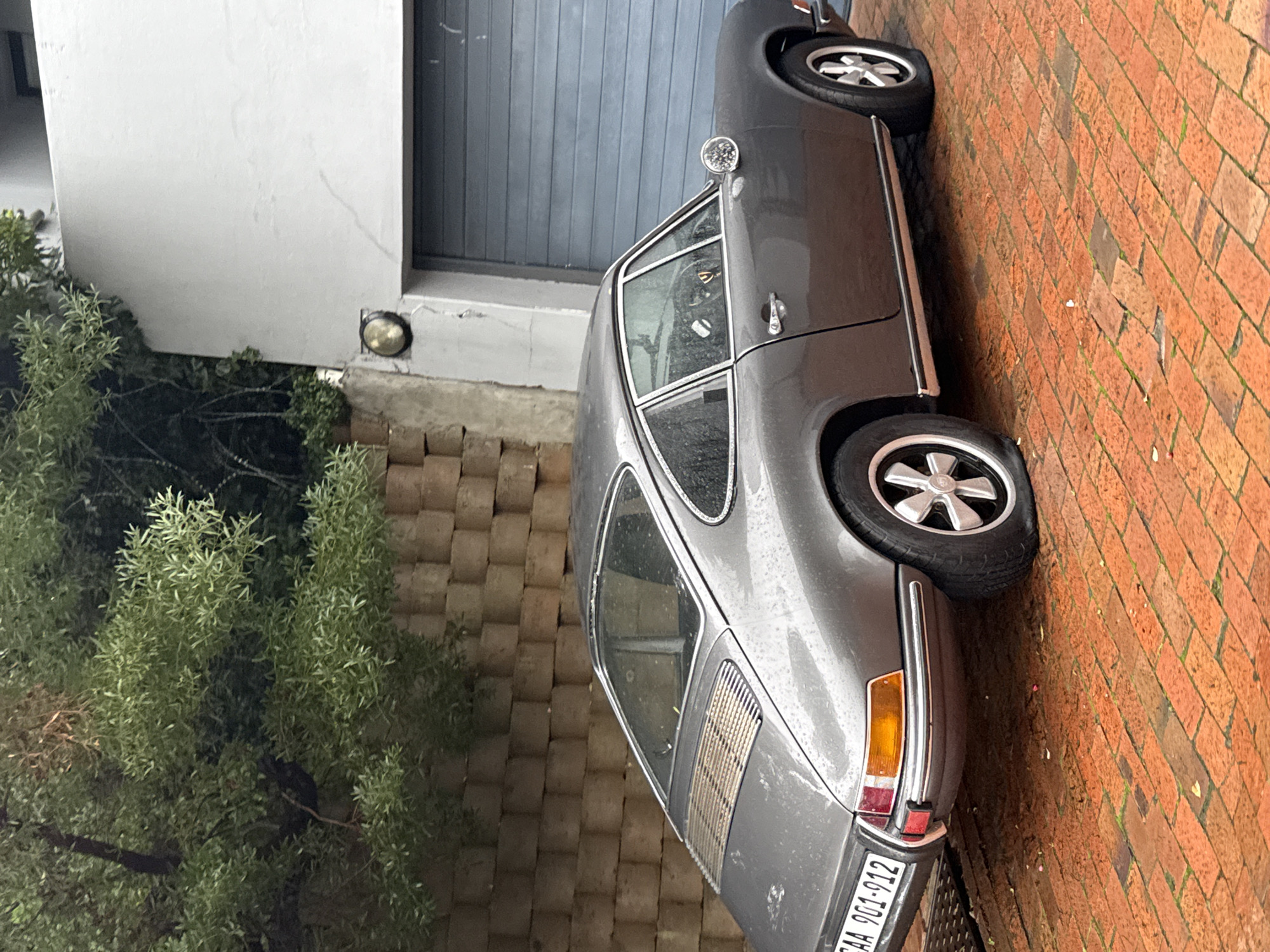 Gray Porsche 911 photographed on brick driveway in Cape Town