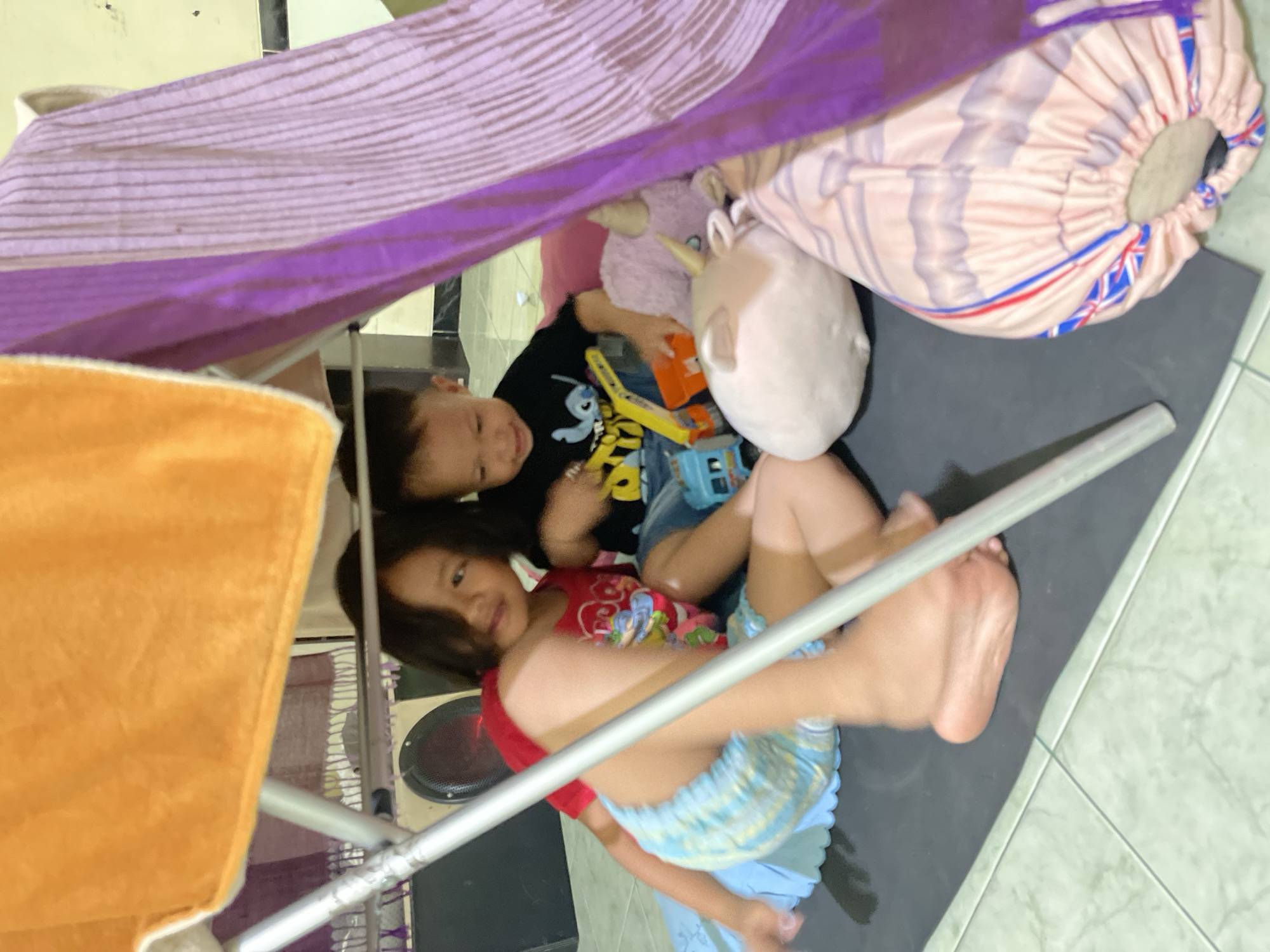 Children play in blanket fort during morning hours