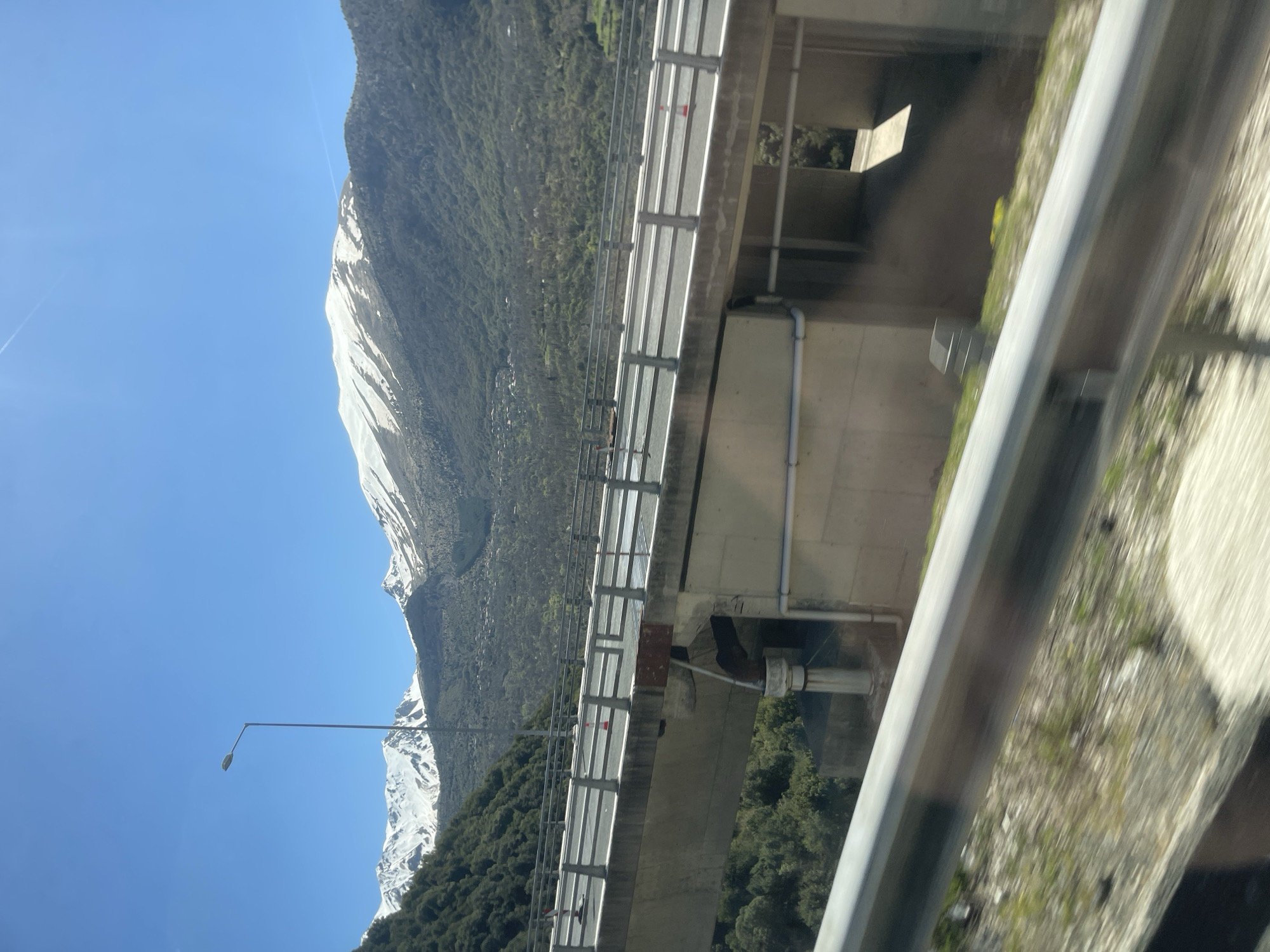 Snow-covered mountain viewed from highway overpass in Metsovo, Greece