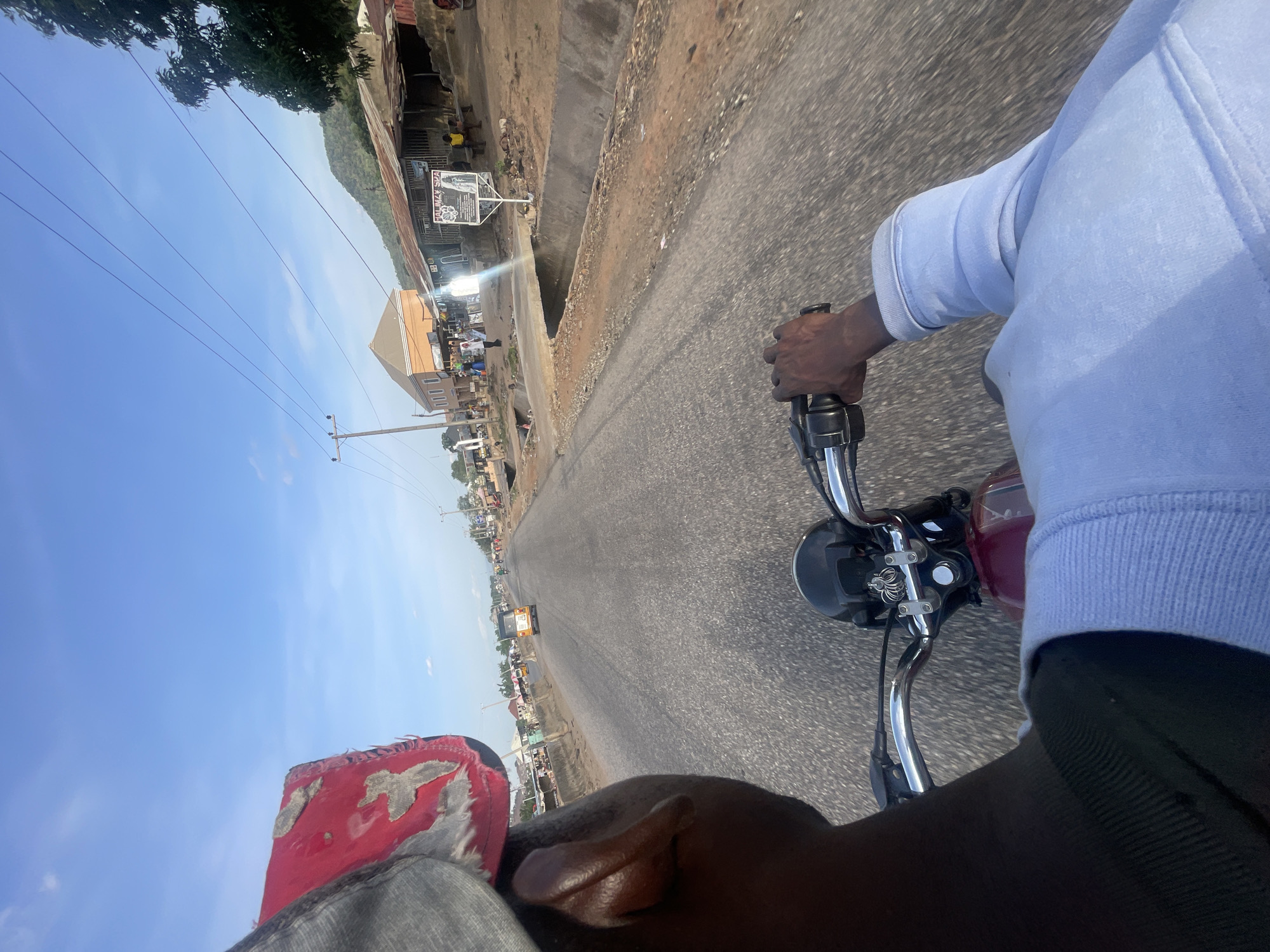 Motorcycle rider travels paved road in Lokoja, Nigeria