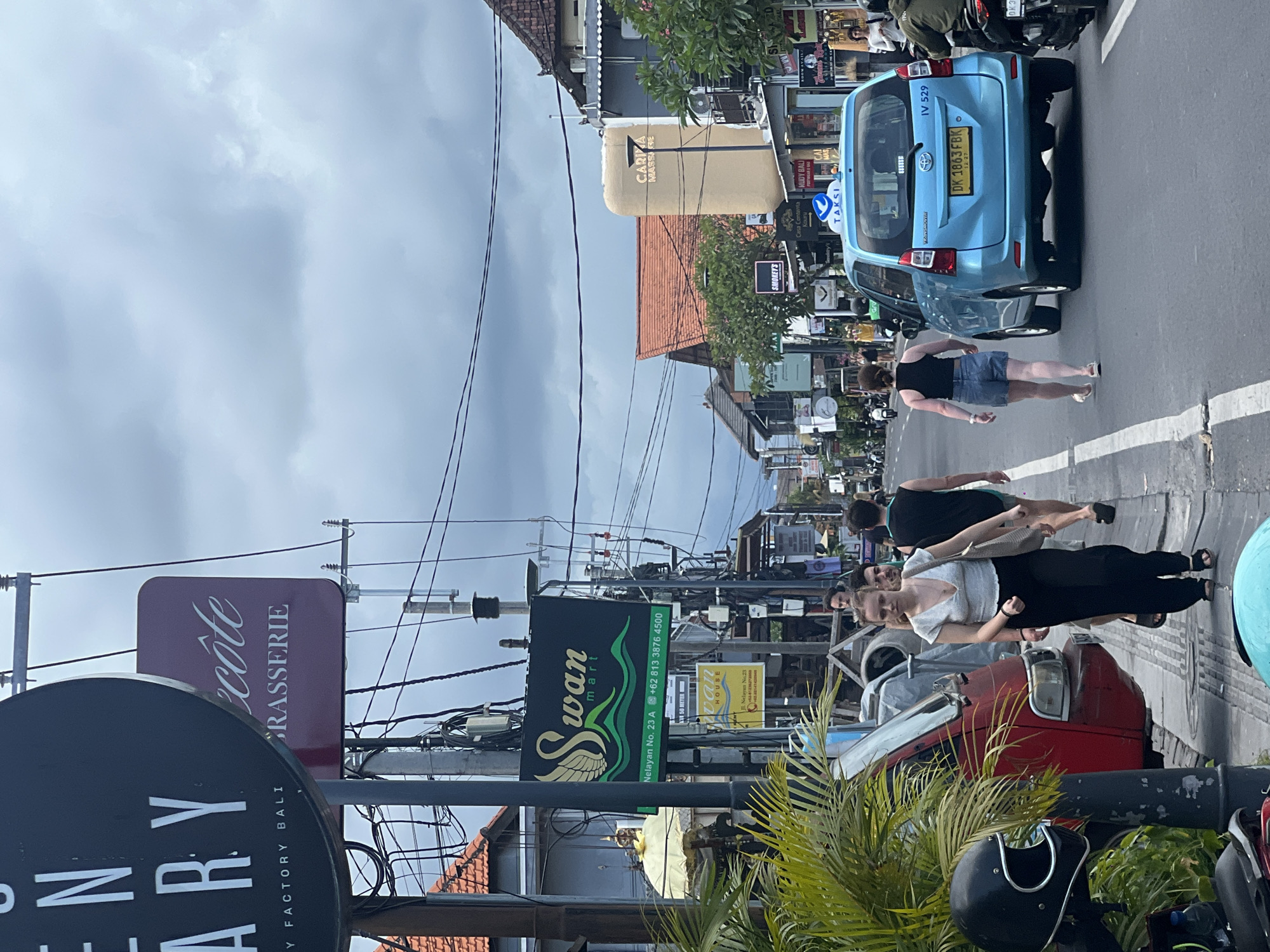 Taxi and pedestrians captured on Canggu street scene