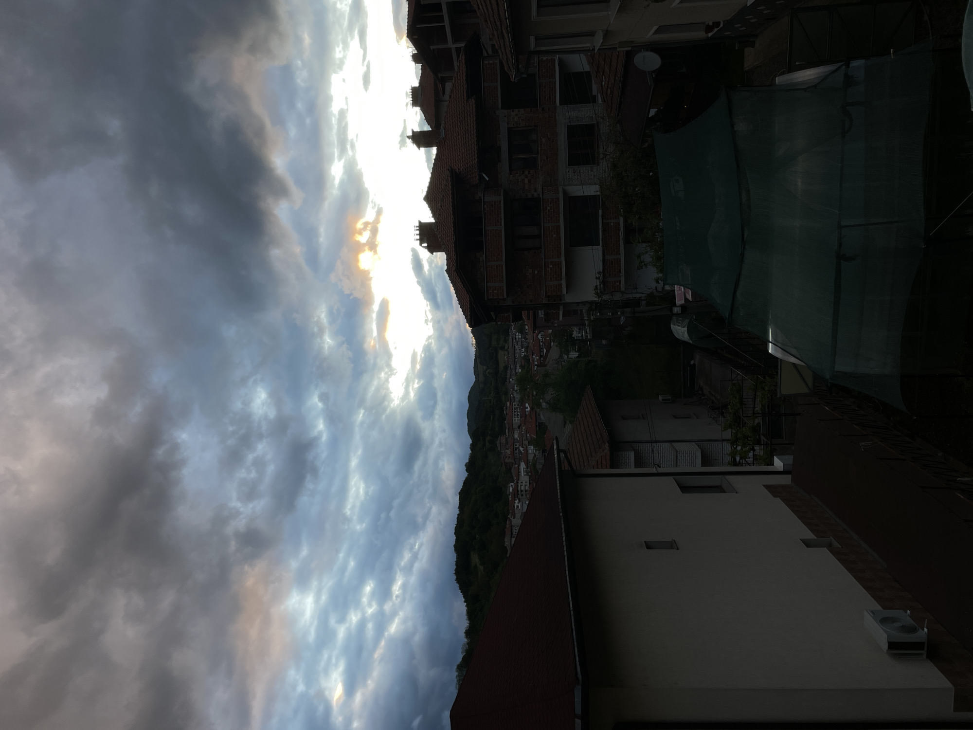 Dramatic clouds captured over Bulgarian hillside town during sunset hours