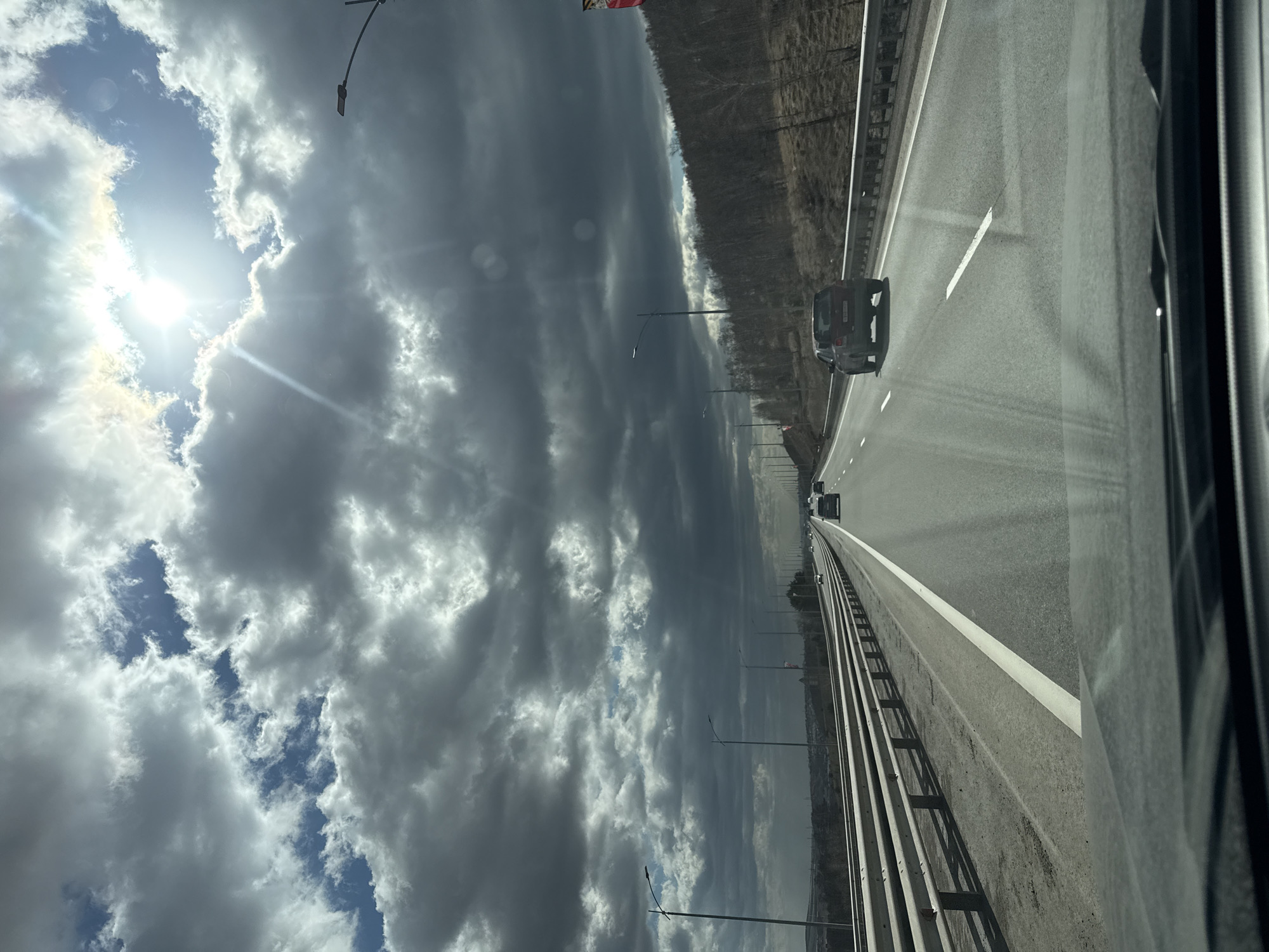 Highway travel documented near Солонцы under dramatic cloudy skies