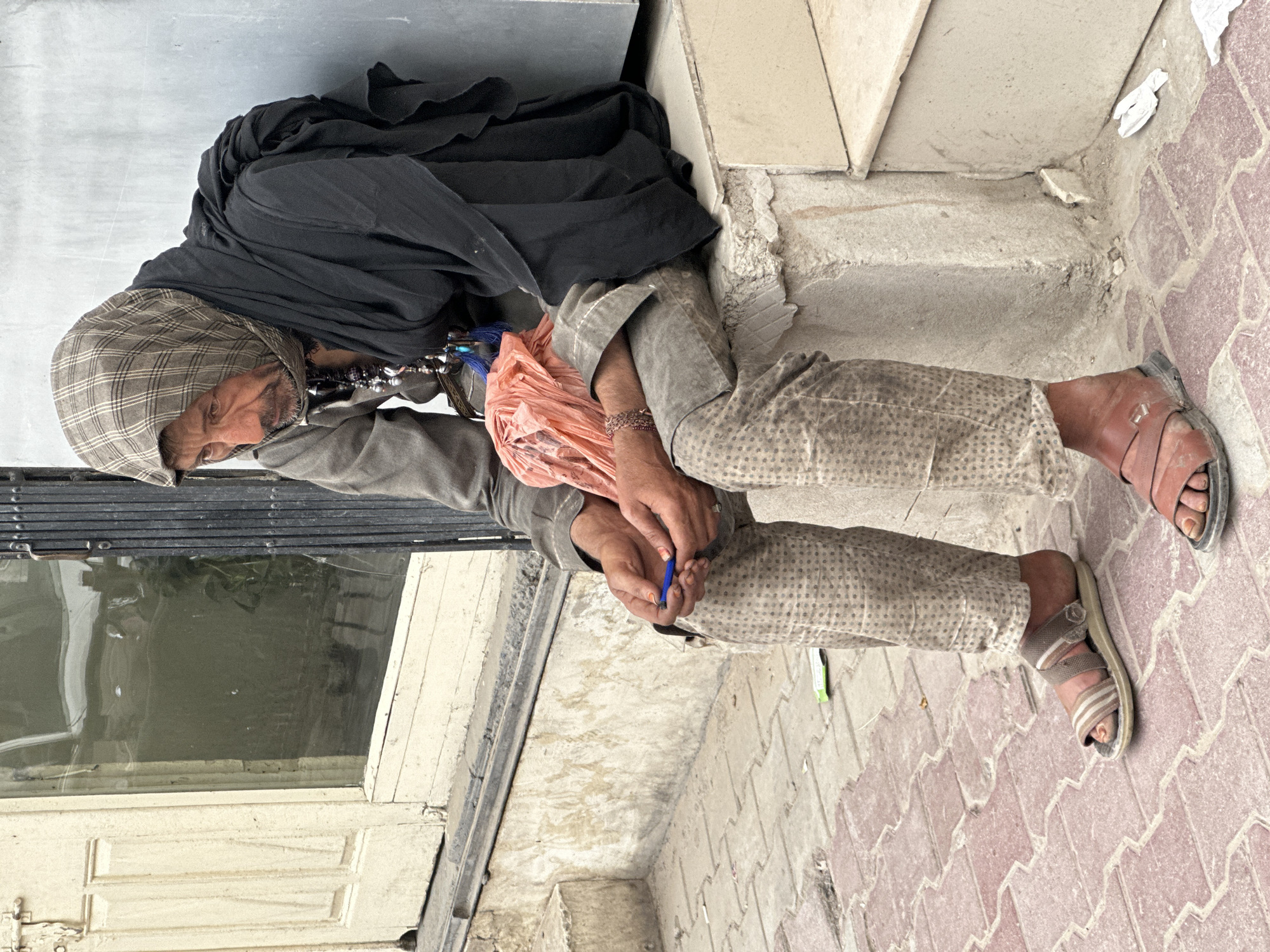 Elderly man rests outside building in Quetta, Pakistan