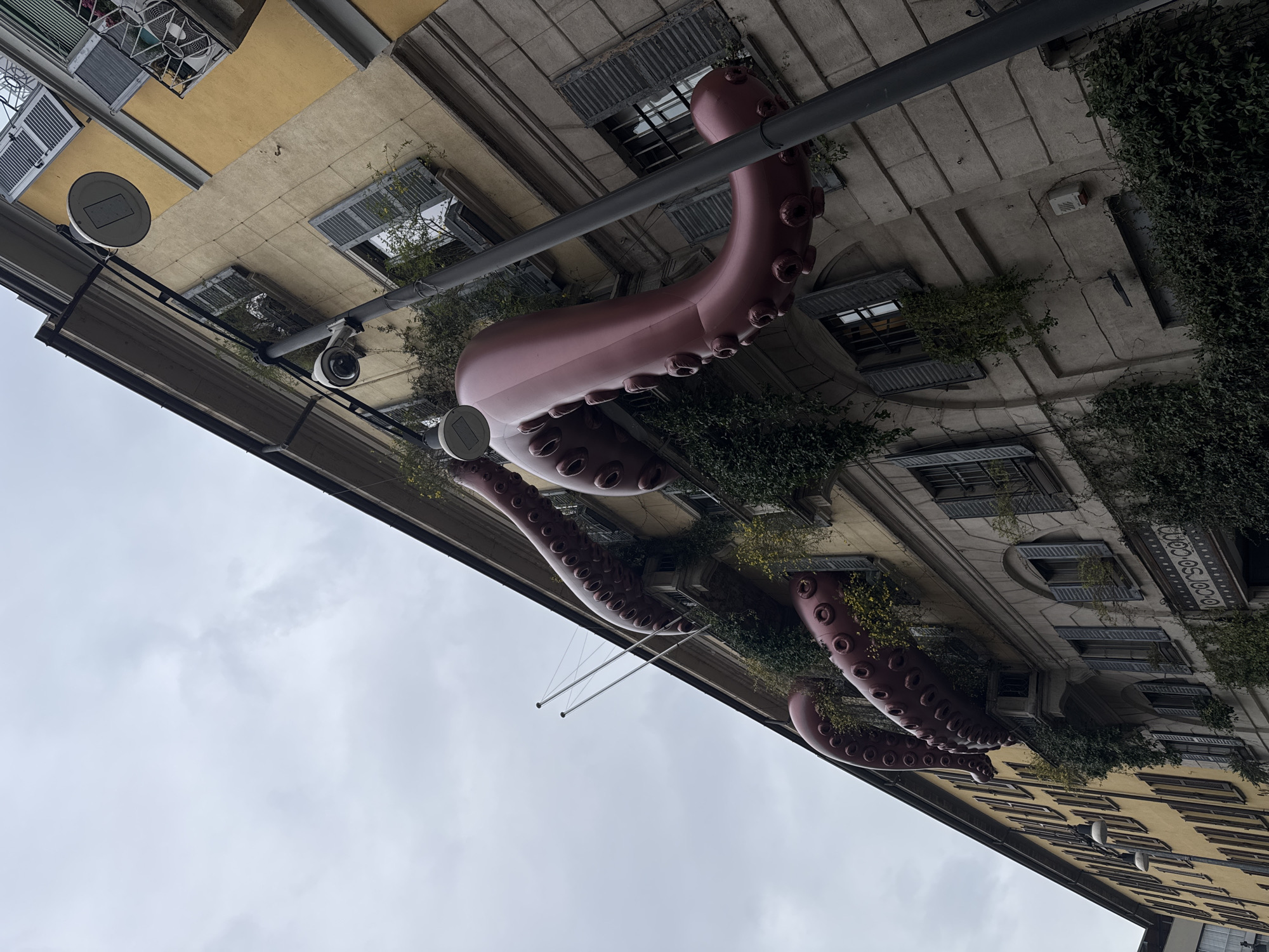 Milan building adorned with inflatable octopus tentacles from windows