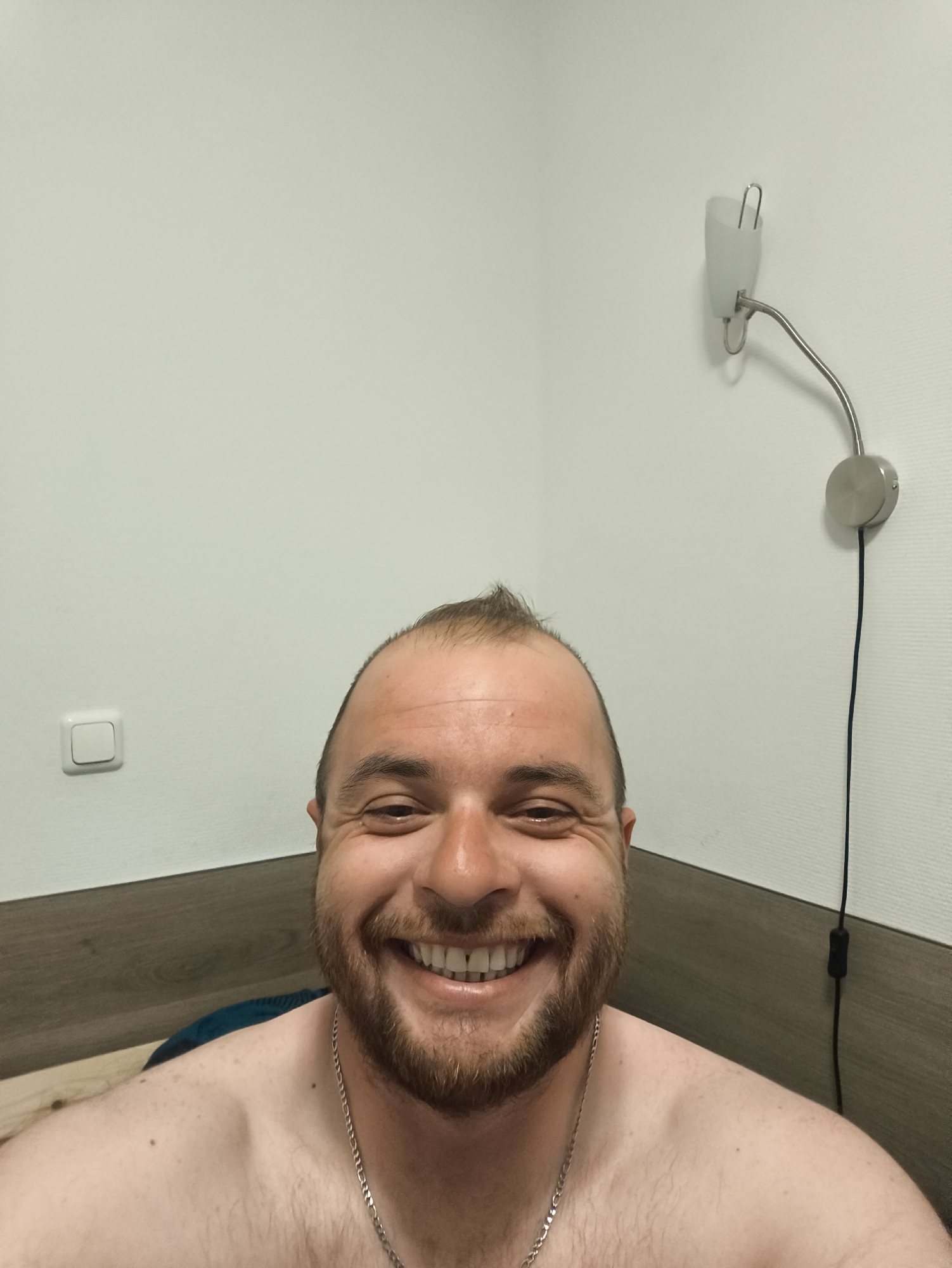 Man observed in bedroom with mounted wall lamp
